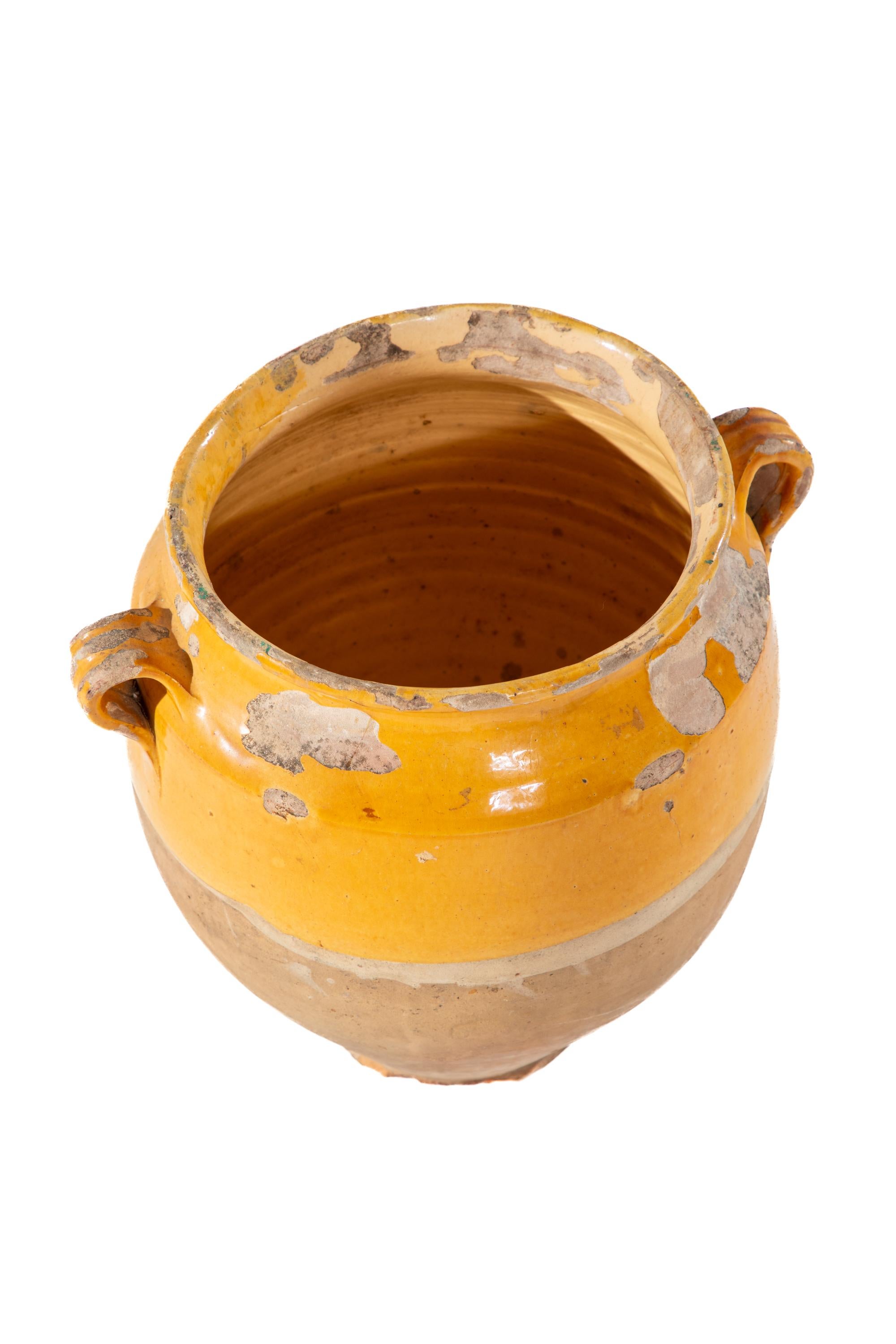 Vase à deux anses en terre cuite.  Partie supérieure émaillée jaune et partie inférieure non émaillée.
Non marqué.