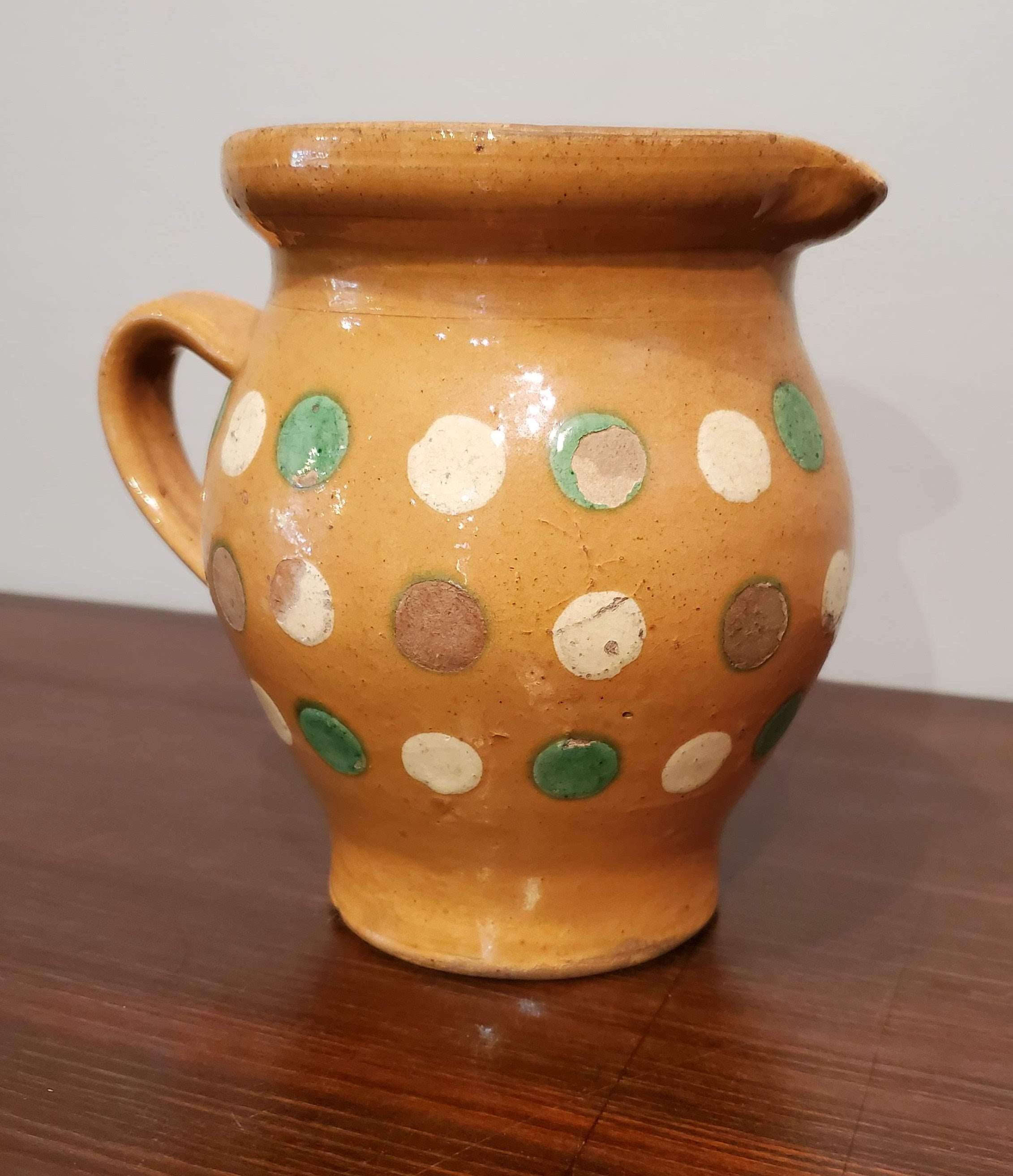 French provincial terracotta milk jug with green and cream polka dot decoration on an ochre ground. Adorable for decoration or for use in your modern kitchen,
Alsace, circa 1870
Measures: 5.5” H, 6.5” W, 4.25” D.
 