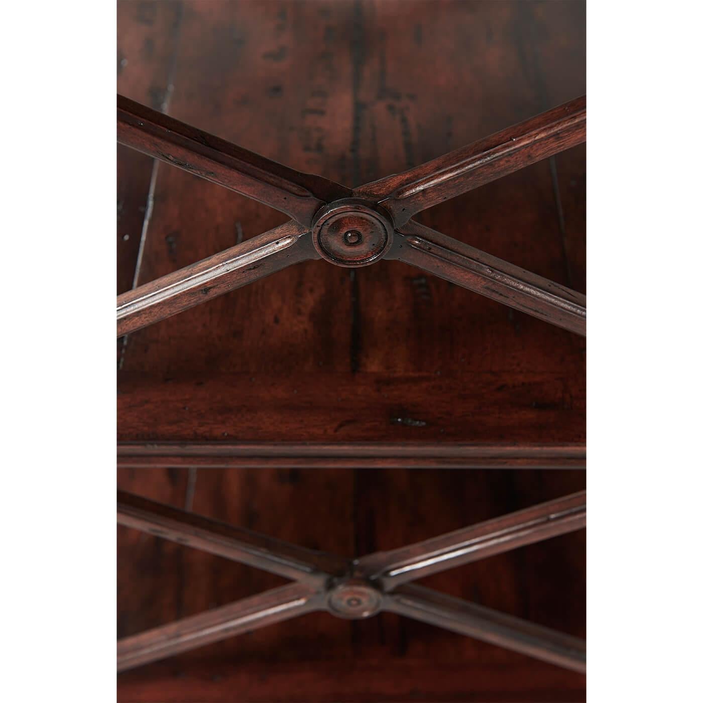 Une étagère à trois niveaux en bois de style provincial français vieilli, le plateau carré à trois quarts de galerie et les niveaux inférieurs avec des supports en 'X' sur les côtés, sur des pieds carrés chanfreinés. 

Dimensions : 22