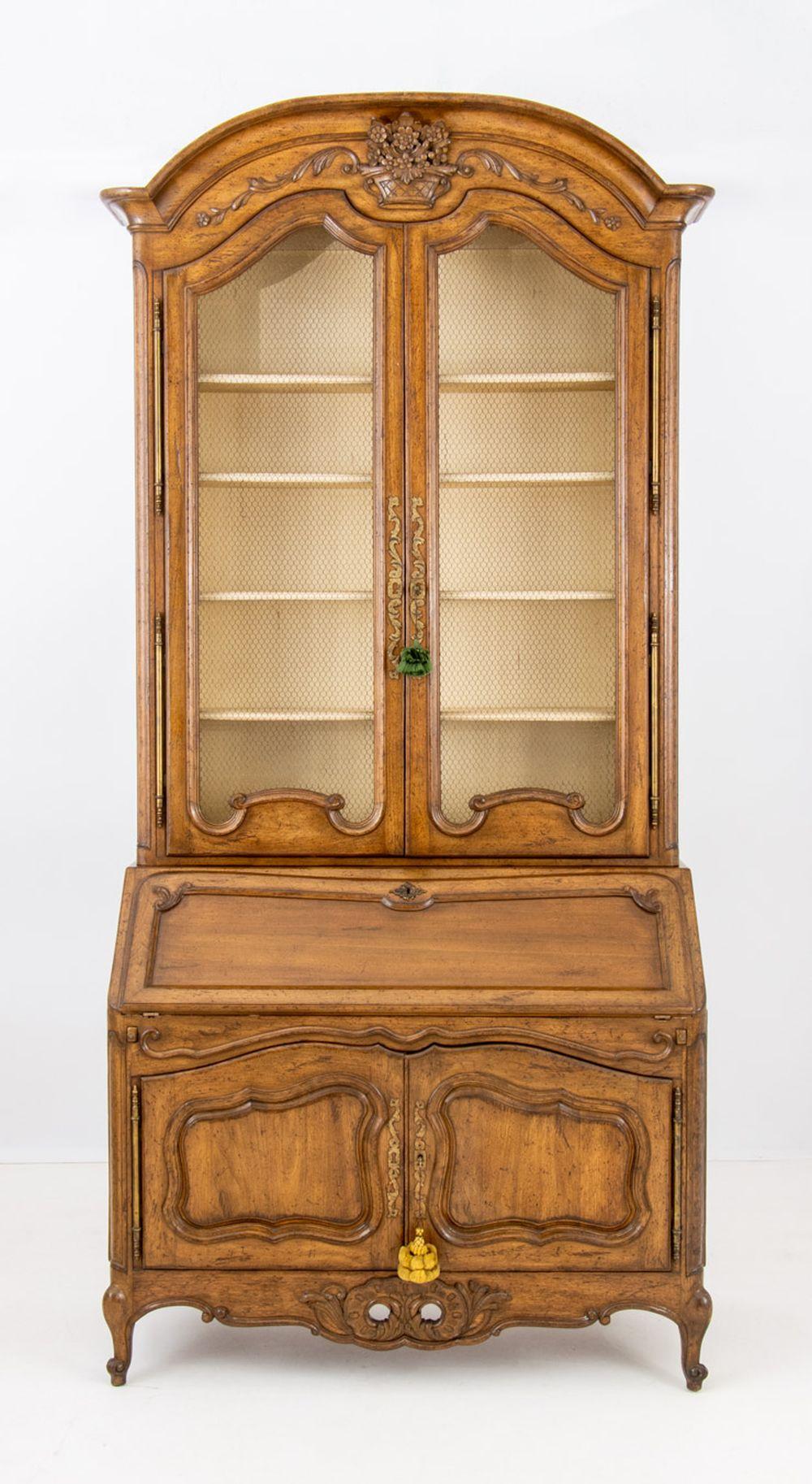 French Provincial Walnut Bureau Bookcase, in two pieces, the top portion with doors opening to five shelves, the bottom piece with slant door opening to gilt-tooled leather writing surface and drawers above a two-door cabinet, with 
