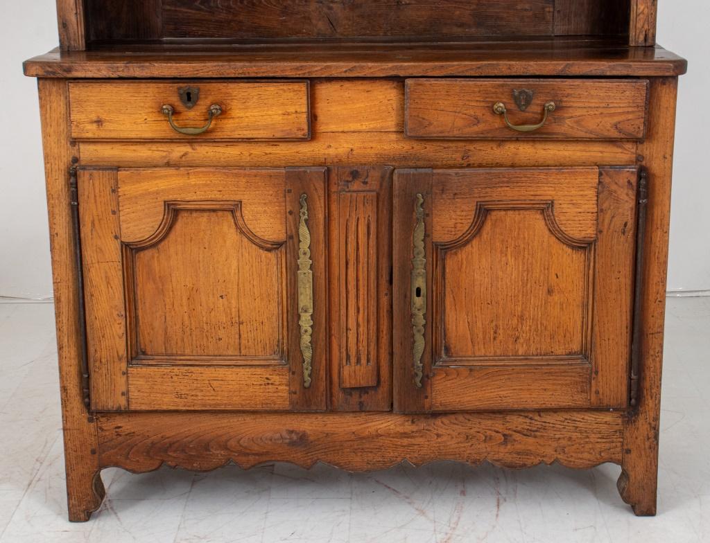 French Provincial walnut buffet a deux corps, or hutch cabinet, with a molded corniced upper corps with a six shelved vaiselier or plate rack above a cabinet with two short drawers and two cabinet doors with wrought iron hinges and fittings,