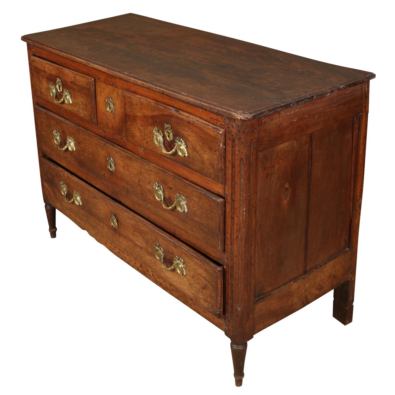 A French Provincial walnut commode with two drawers at top and two large drawers below, on straight legs, with gilt metal hardware.