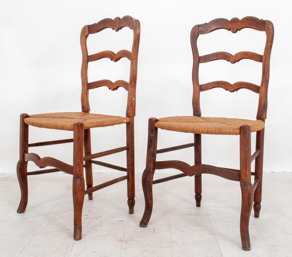 Pair of French provincial walnut ladder-back side chairs, each with shaped crest rail above rush seats on four legs, 1890s or later. 

Dealer: S138XX