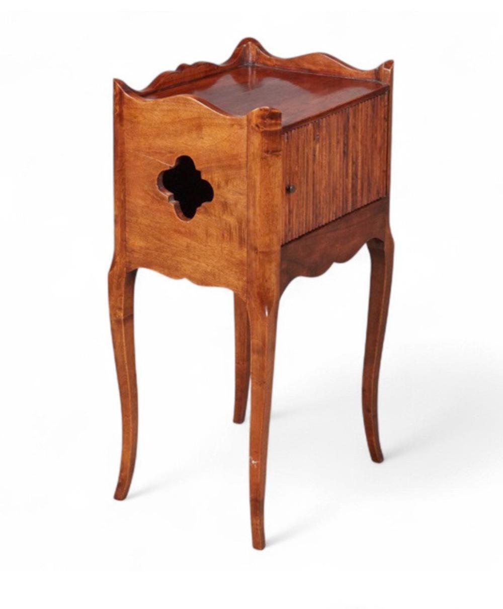 This is a charming French walnut night stand in walnut that is a copy of a 19th century provincial stand. The false tambour front adds a playful  take on the original sliding tambour door. The night stand is in good original condition and ready for
