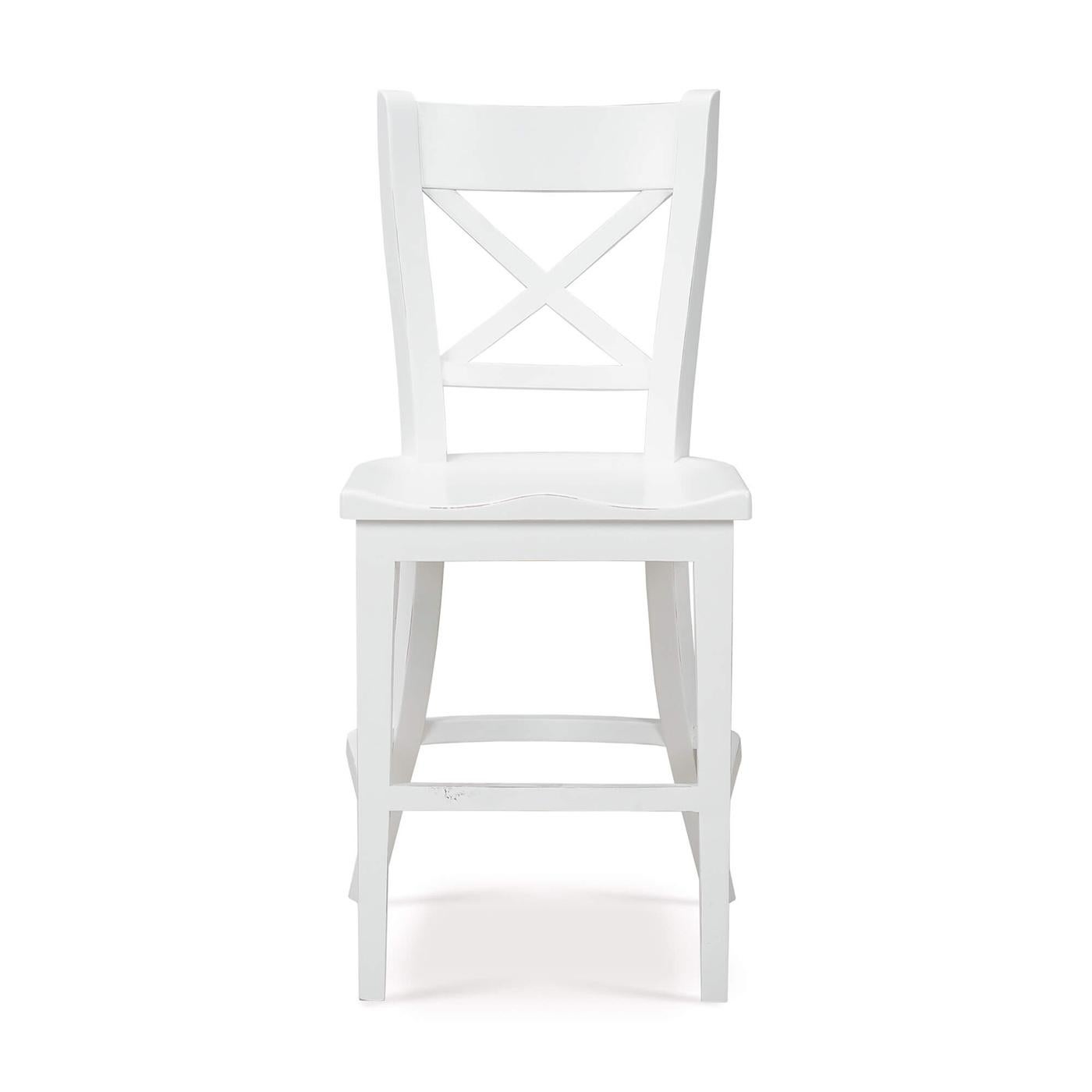 Un mix perfetto di charme tradizionale e funzionalità moderna. Questo sgabello da bancone presenta una struttura in legno massiccio con una finitura verniciata in bianco architettonico leggermente invecchiata, che garantisce una lunga durata e un