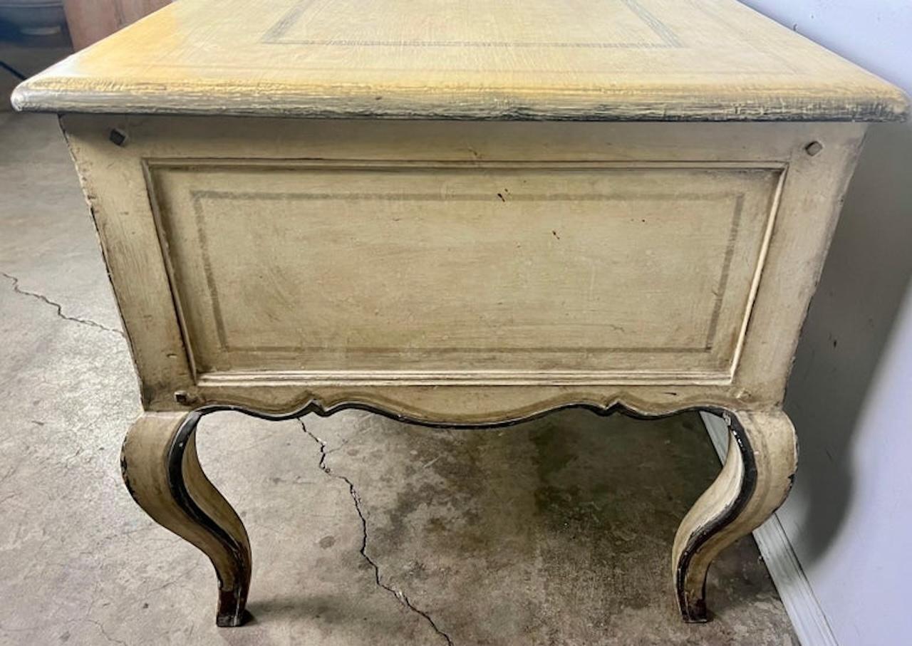 Bureau de style provincial français peint du début du 20e siècle. Le bureau repose sur quatre pieds cabrioles qui se terminent par des pieds à tête de bélier. La pièce est magnifiquement peinte dans un style usé. Finition délavée. Il y a quatre