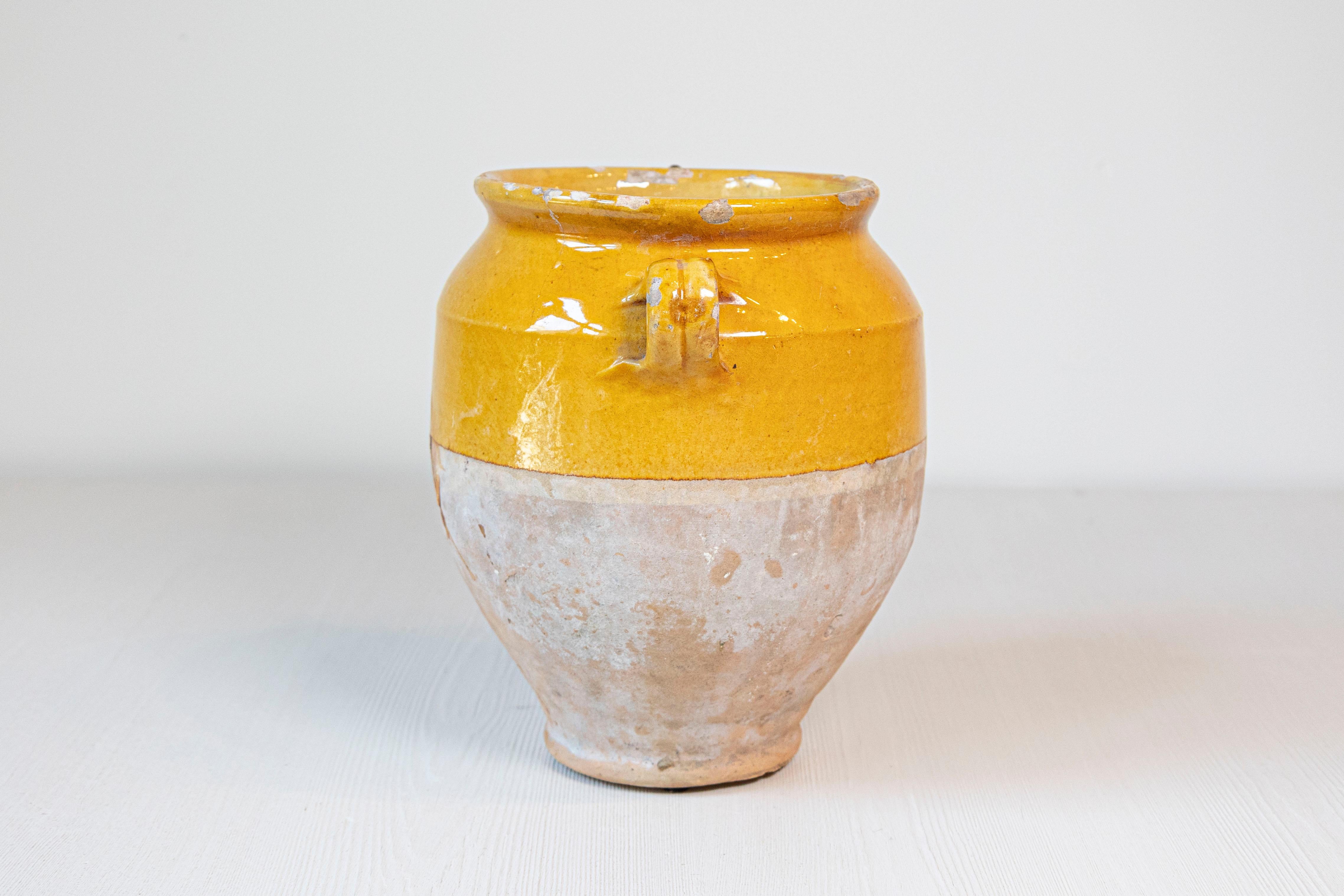 Un pot à confit rustique de style provincial français du 19e siècle avec une glaçure jaune et des poignées doubles. Entrez dans le charme rustique de la campagne française avec cet authentique pot à confit provincial français du XIXe siècle, une