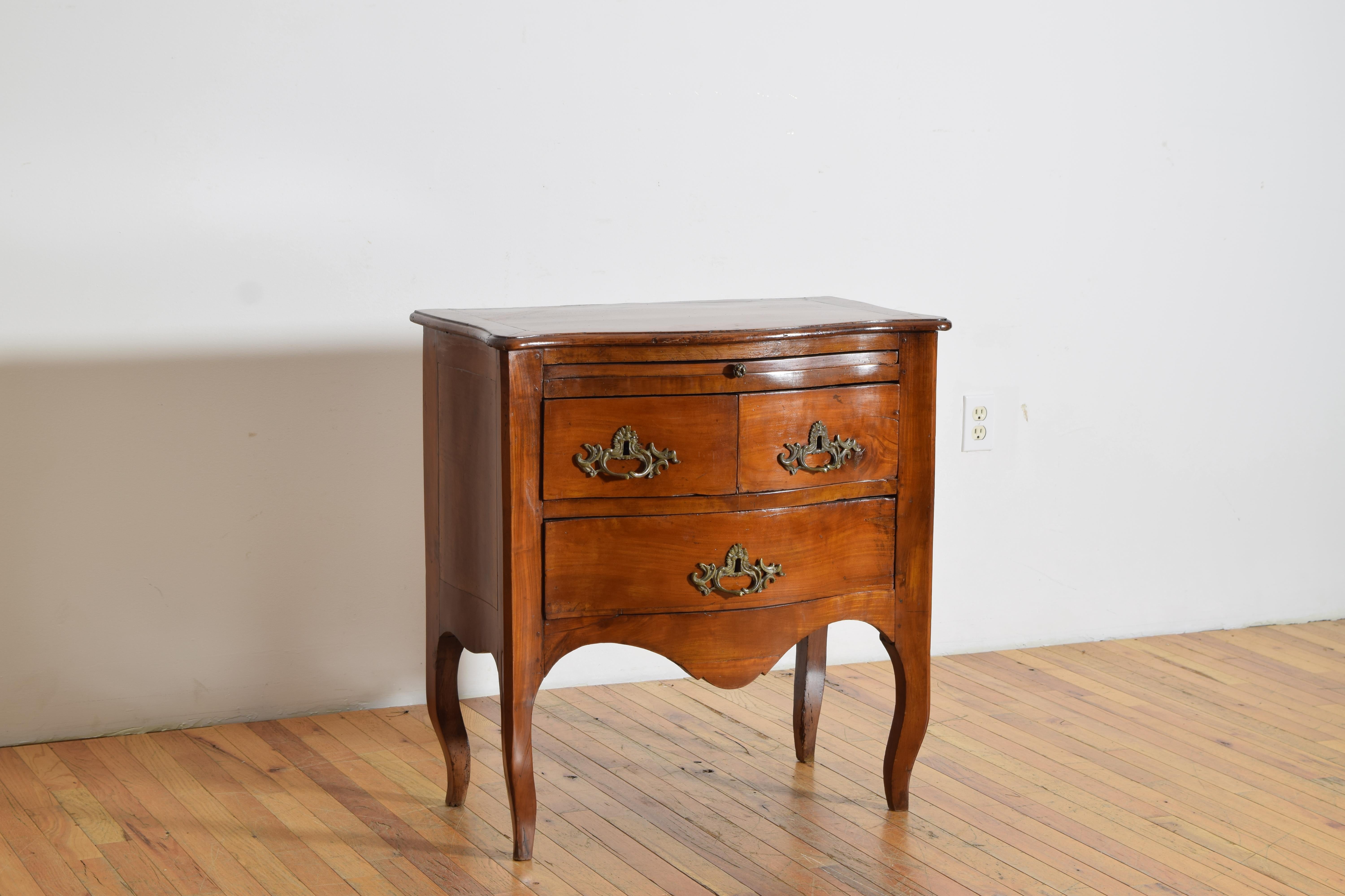 Costruito interamente in ciliegio, ha un piano a forma di serpentina sopra una cassa conforme che ospita un piano di scrittura estraibile sopra due piccoli cassetti sopra un cassetto più grande, la cassa è sollevata su gambe cabriole.