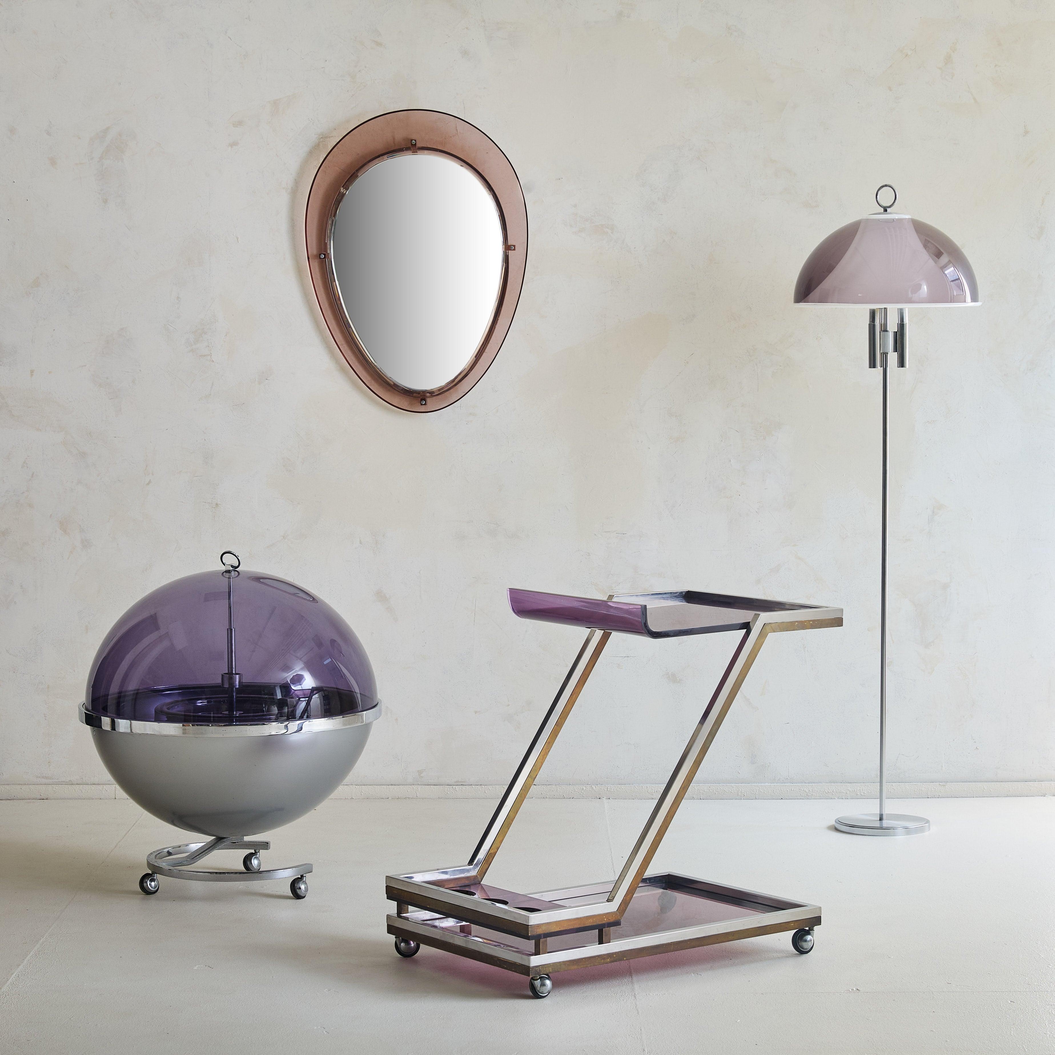 A rare 1970s Space Age bar cart designed by Pierre Cardin. Crafted of purple smoked plexiglass and chrome, this bart cart features a spherical silhouette that opens to reveal an interior fitted with four bottle holders and spacious storage. The