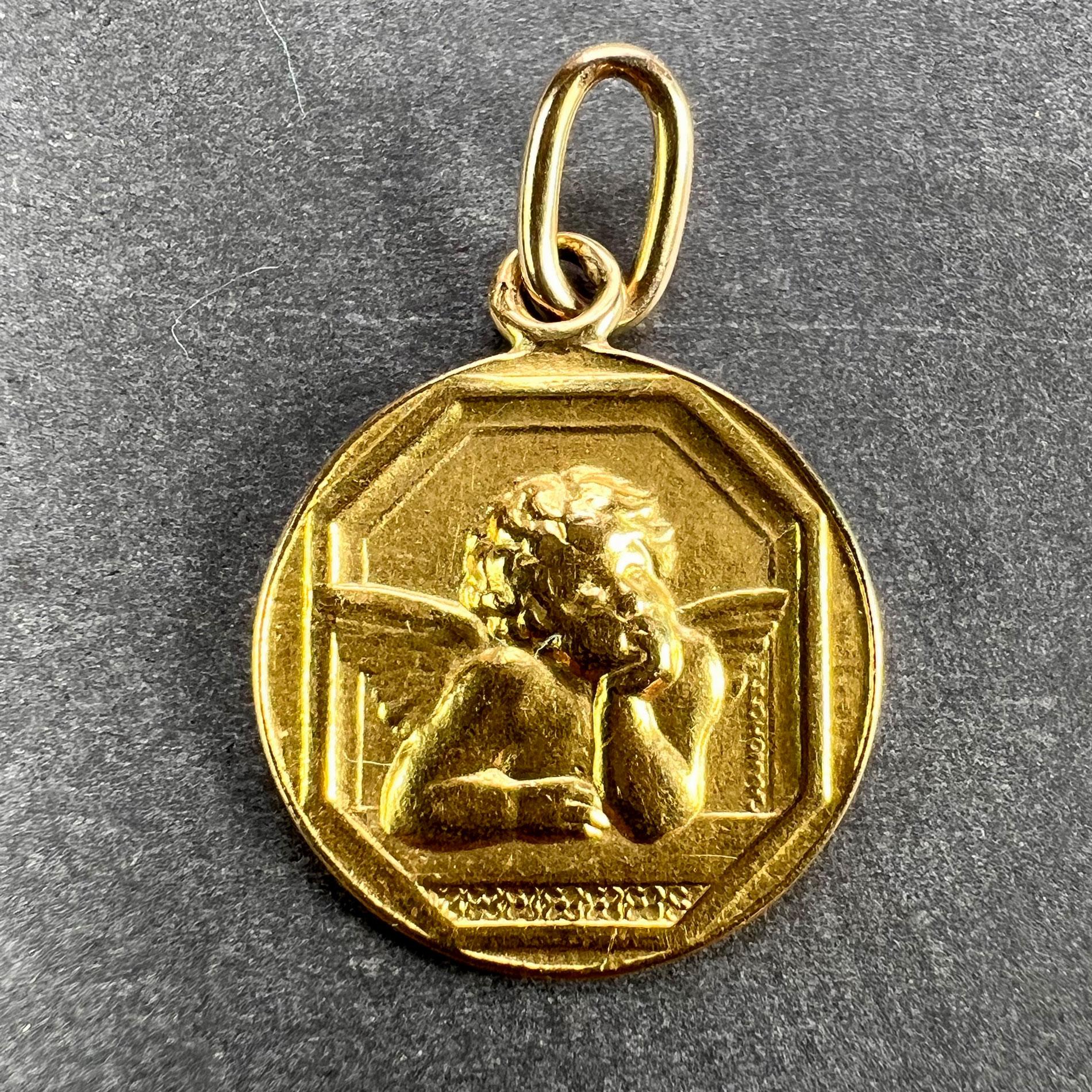 An 18 karat (18K) yellow gold pendant designed as a round medal depicting the Raphael’s cherub. The reverse depicts roses and is engraved with the date ‘9 Mars 1942’. Stamped with the eagle’s head for French manufacture and 18 karat