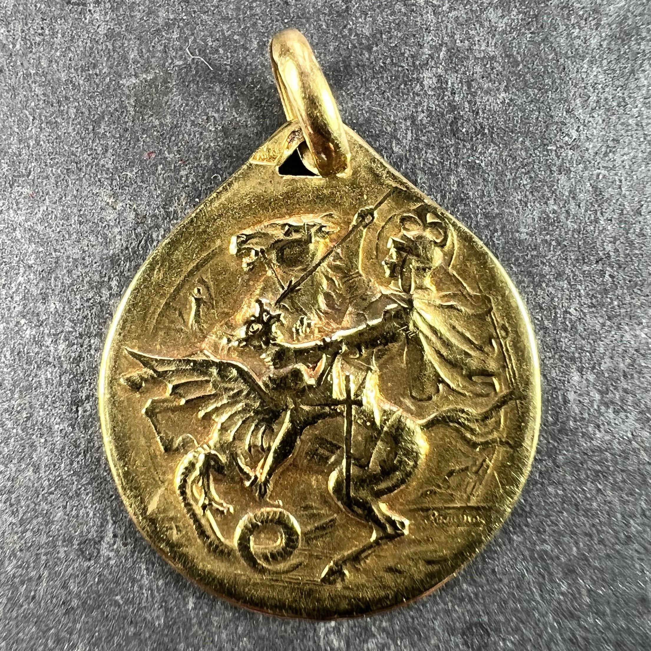 A French 18 karat (18K) yellow gold charm pendant designed as a medal depicting St George on a rearing horse defeating the dragon signed F. Rasumny. The reverse depicting a ship in a storm with ‘In Tempestate Securitas’ (Safety in the Storm) below