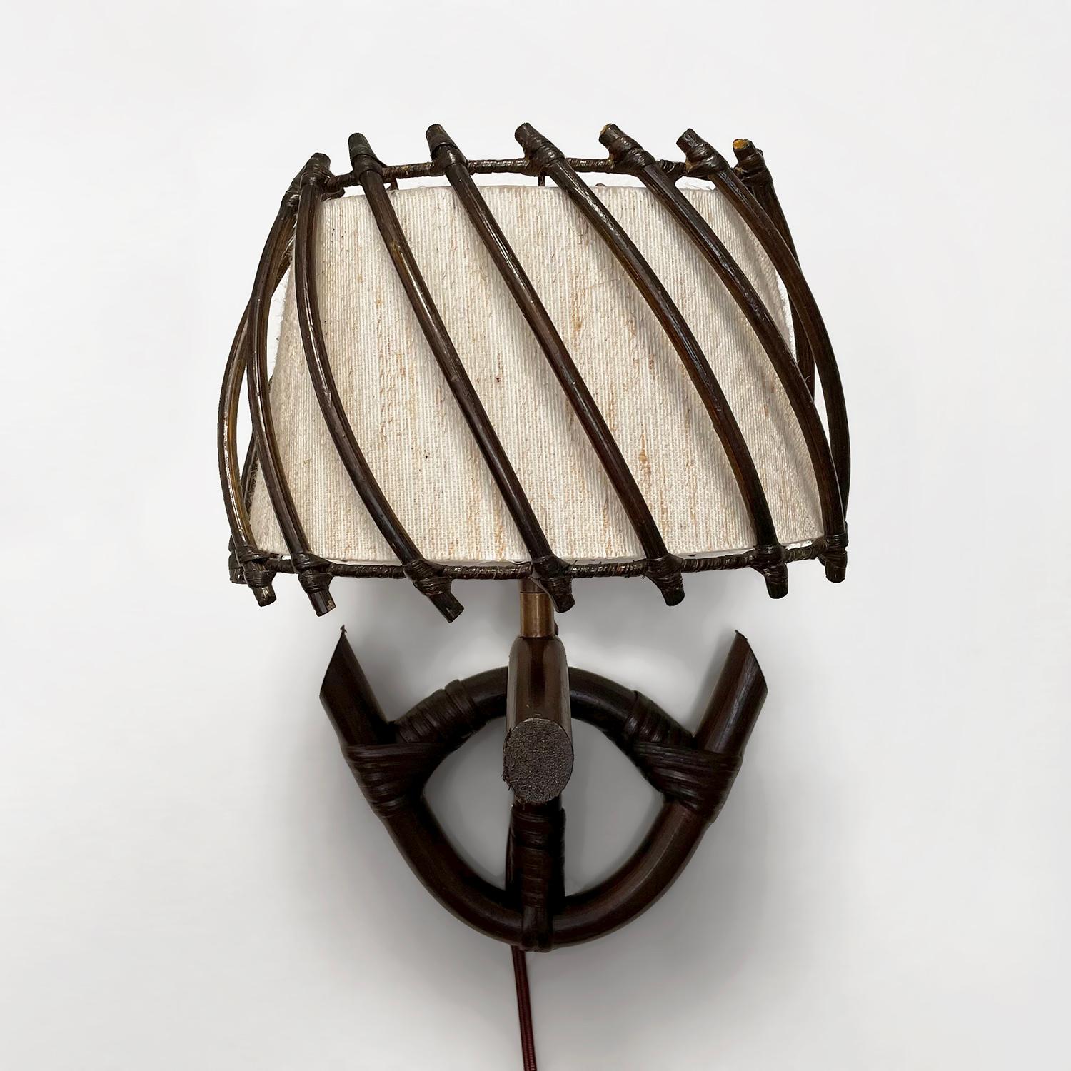French rattan and bamboo sconces in the style of Louis Sognot
France, circa 1960’s 
Hand sculpted rattan and bamboo create these handsome sconces
Original natural fiber shades
Patina from age and use 
Newly rewired.