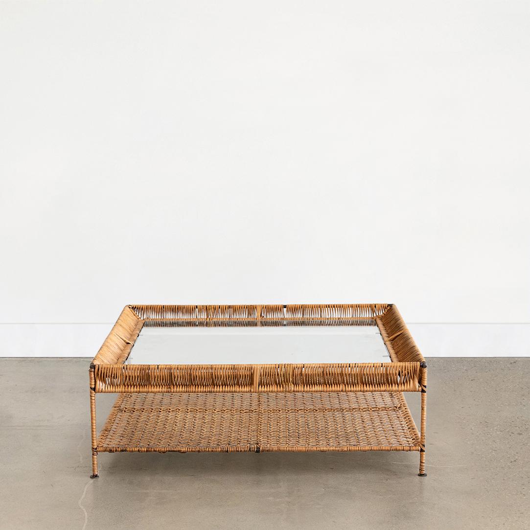 Great square two-tier rattan and glass coffee table from France. Metal frame wrapped in rattan with woven rattan lower shelf and new square glass top. Functional and unique design.