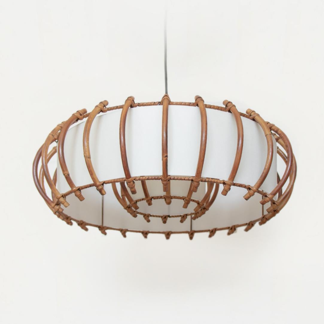 Circular rattan ceiling light from France, 1960's. Original rattan frame with nice patina and age. Second smaller interior rattan shade with single bulb and black cord to hang. Overall height is adjustable, can be hung as a pendant or closer to the