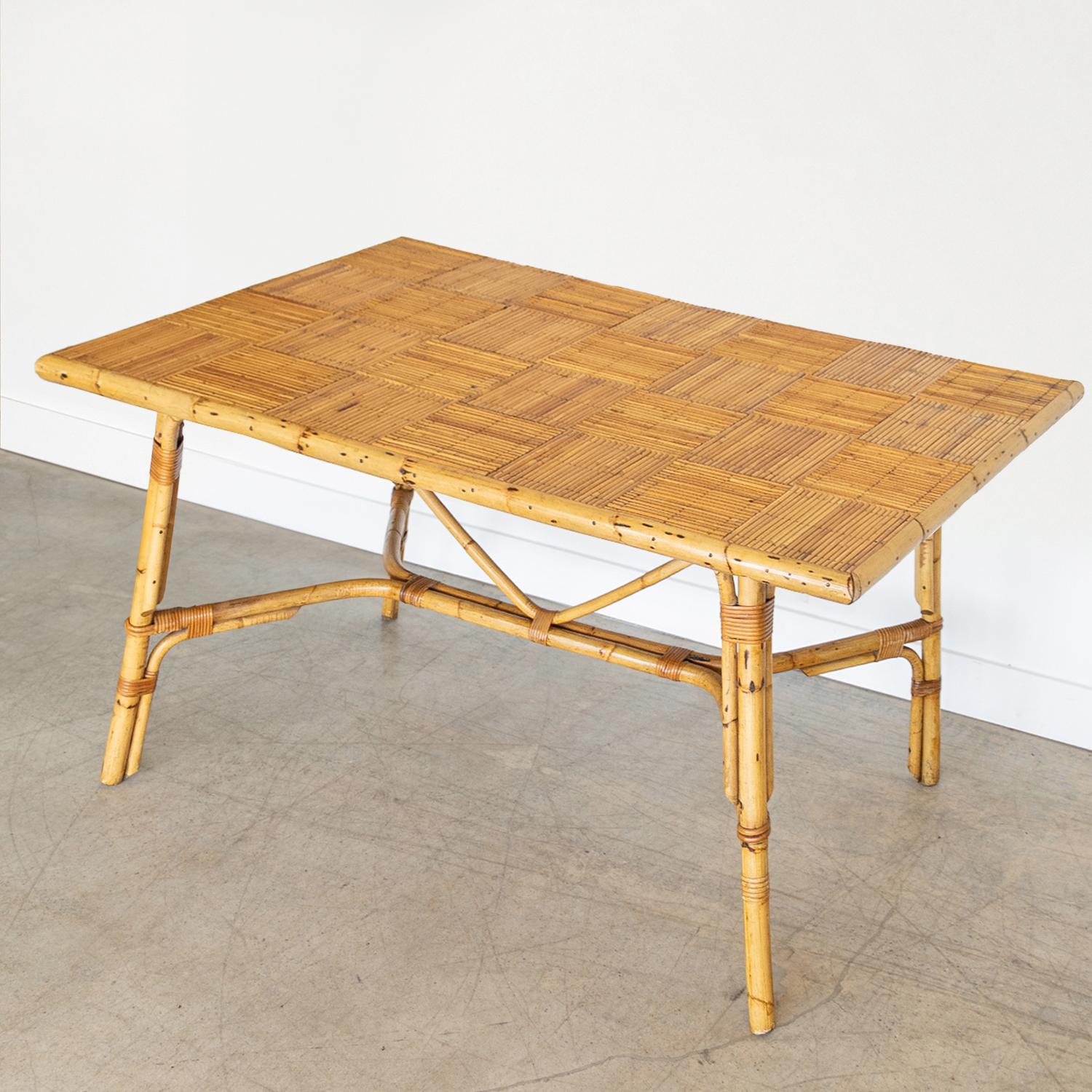 Incredible rattan dining table by Adrien Audoux and Frida Minet from France, 1960's. Rectangular rattan top with checked pattern surface and four bamboo legs with wrapped rattan detailing. All original rattan finish shows age, patina, and wear.