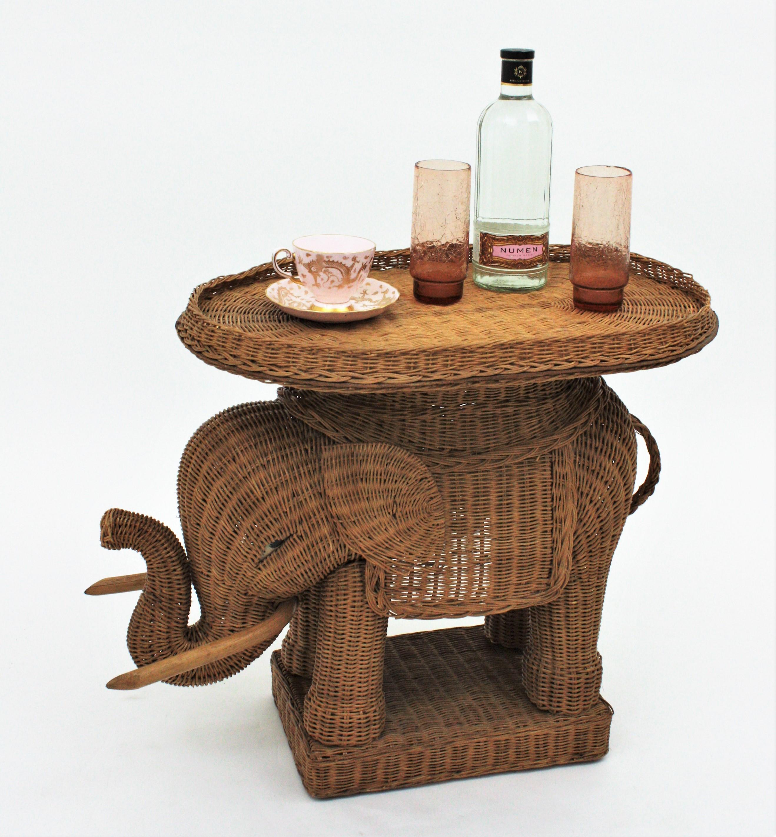 Eye-catching woven rattan end table or drinks table with removable tray top. France, 1950s
This elephant shaped end table stand was beautifully constructed in hand braided rattan / wicker accented with wood tusks. The tray top is removable so it