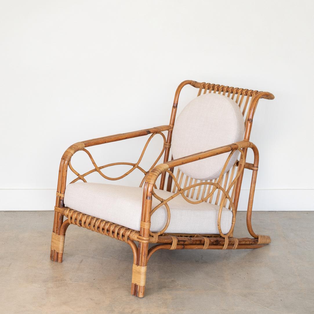 Incredible 1950's French rattan lounge chair with cushions. Sculptural slatted rattan frame with reclined back and unique loop detail on sides. Wrapped rattan detailing on corners, all original with nice age and patina. New cushions with circular