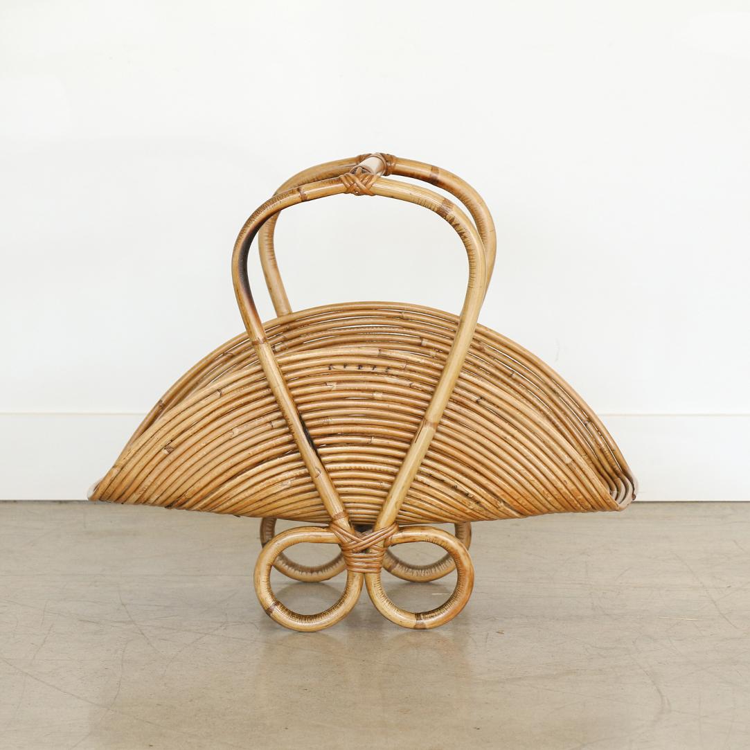 French rattan magazine rack with curved rattan detailing. Great condition with perfect coloring and patina. Unique and eye-catching piece.