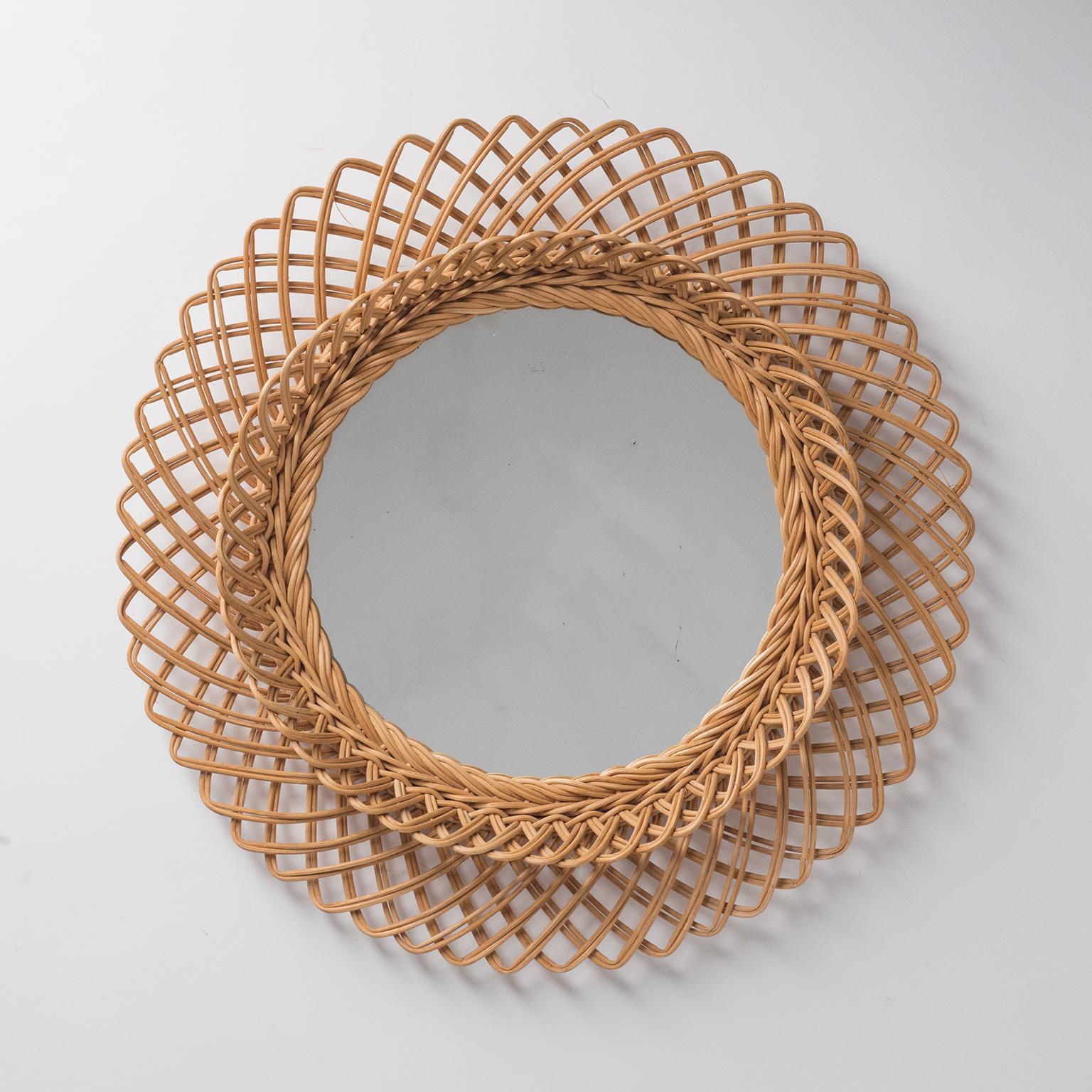 French rattan or wicker mirror from the 1960s. Unusual design with two tiers and extra depth. Diameter of visible mirror area is 9inches/23cm.