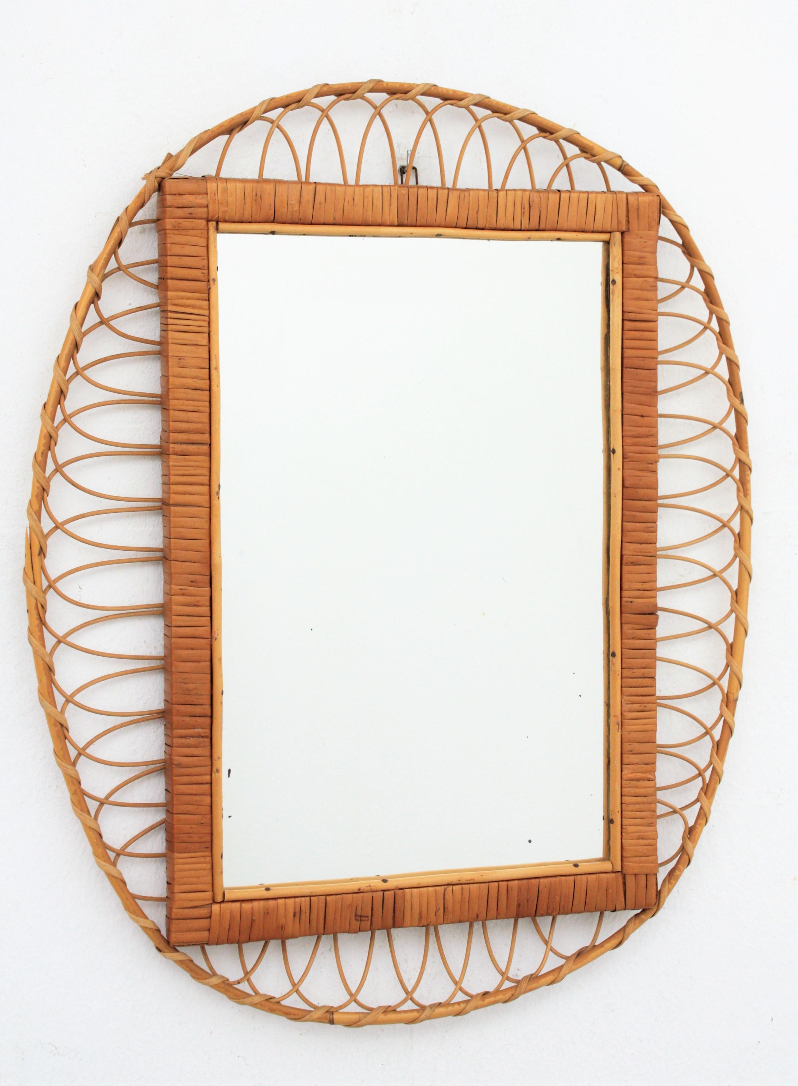 1960s handcrafted French Riviera rectangular mirror with oval rattan frame
This handcrafted mirror is made by a rattan oval frame surrounding a rectangular glass wraped with rattan.
This mirror has all the taste of the Midcentury French Riviera