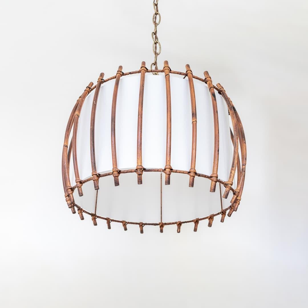 Circular rattan pendant light from France, 1960's. Original rattan frame with nice patina and age. Newly replaced silk shade with single bulb and new brass chain and canopy. Newly rewired with brown twisted cloth cord. Takes one E12 base bulb, 40 W