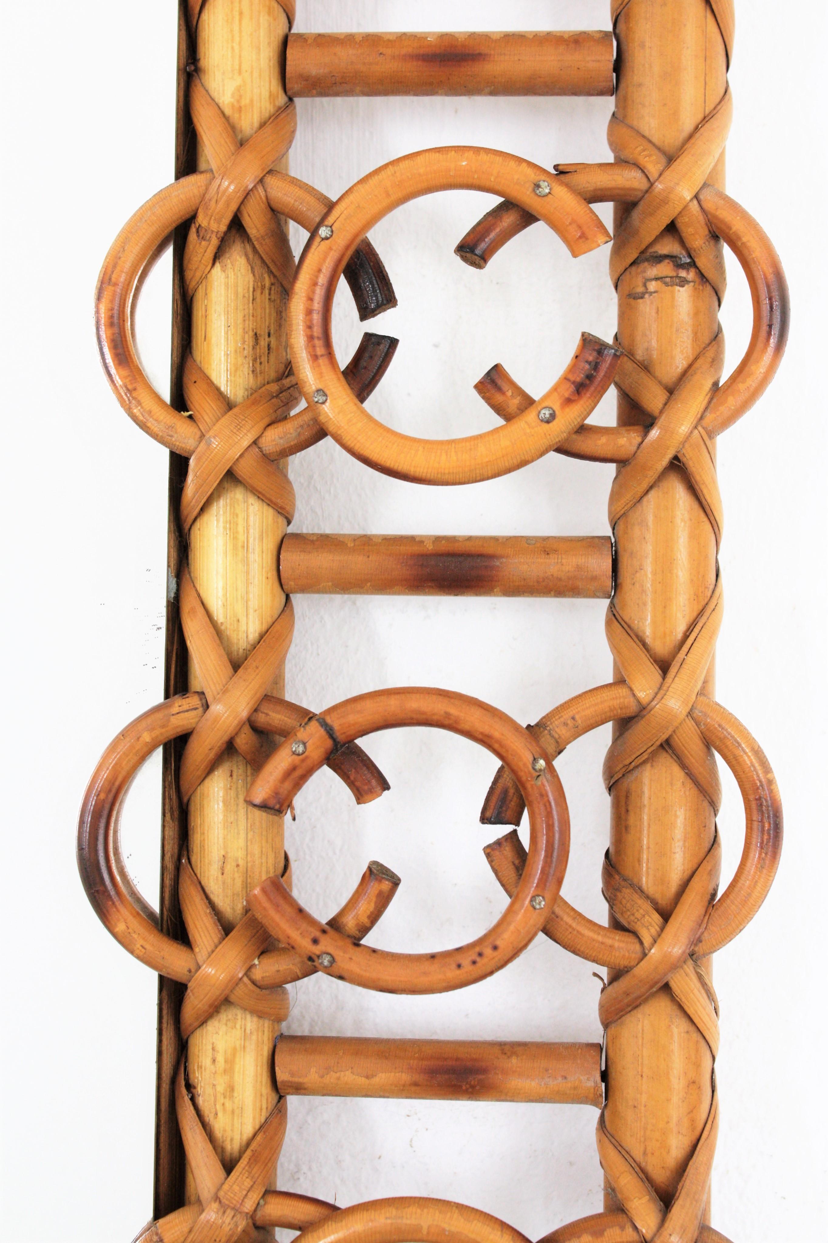 1950s French Riviera rattan rectangular mirror with rings accents on the frame.
Unusual handcrafted rattan rectangular mirror accented by circles decorations.
This stylish mirror has all the taste of the French Mediterranean coast style. Highly