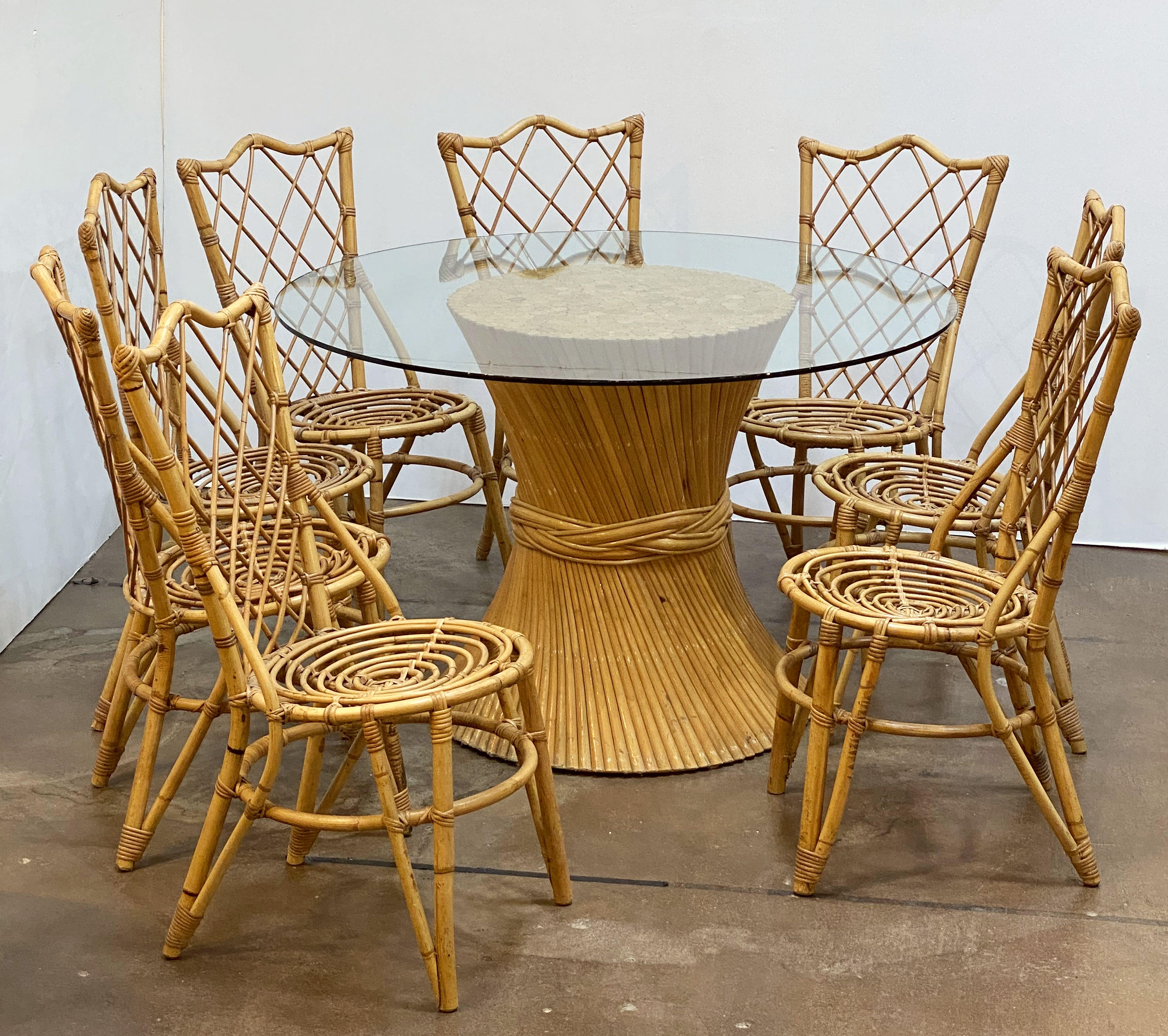 A fine rattan round table or center table, featuring a large circular glass top over a stylish design of spiral bound bundle of rattan, attributed to McGuire Furniture Company.

Dimensions: Height 29 7/8 inches x diameter 47 1/2 inches.

An iconic