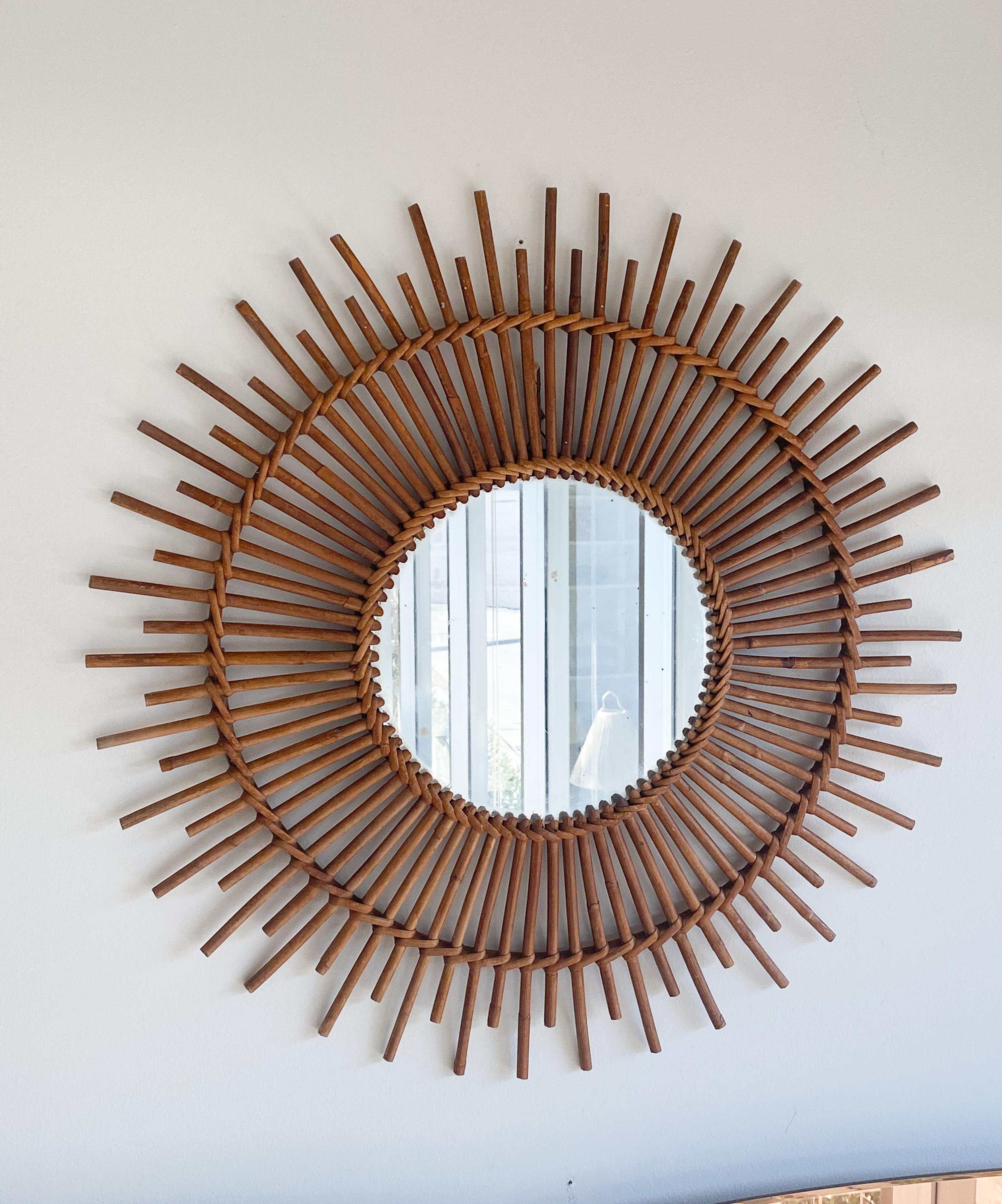 Large French rattan sunburst mirror with rattan arms. Nice vintage condition with original mirror.