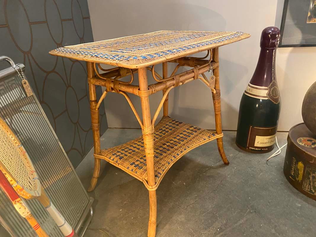 French rattan table from France, Art Nouveau.
The small rectangular table has a tabletop made entirely of rattan wicker, as well as another shelf at foot level. The table captivates with its beautiful curved design, which it owes mainly to the