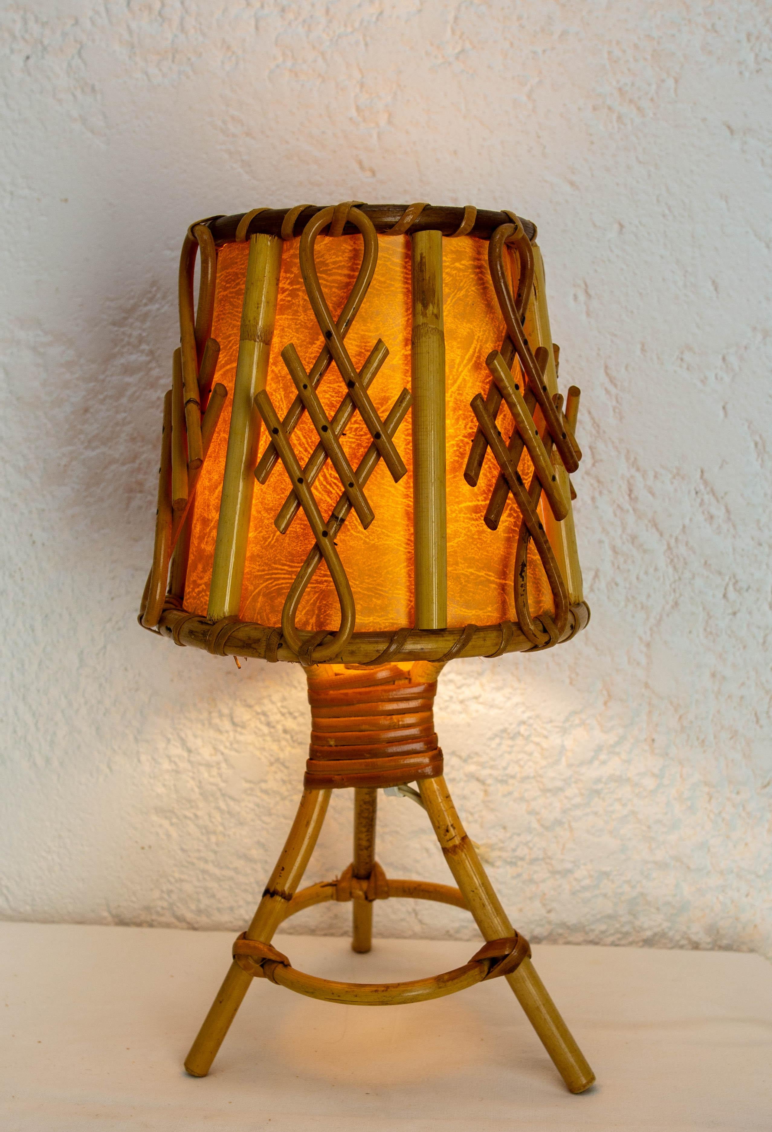 Petite lampe de table en rotin fabriquée en France vers 1950.
Un grand soin a été apporté à la réalisation de cet objet, qui est encore en parfait état. 
A noter un petit décalage au niveau de l'articulation du cercle reliant les trois pieds de la