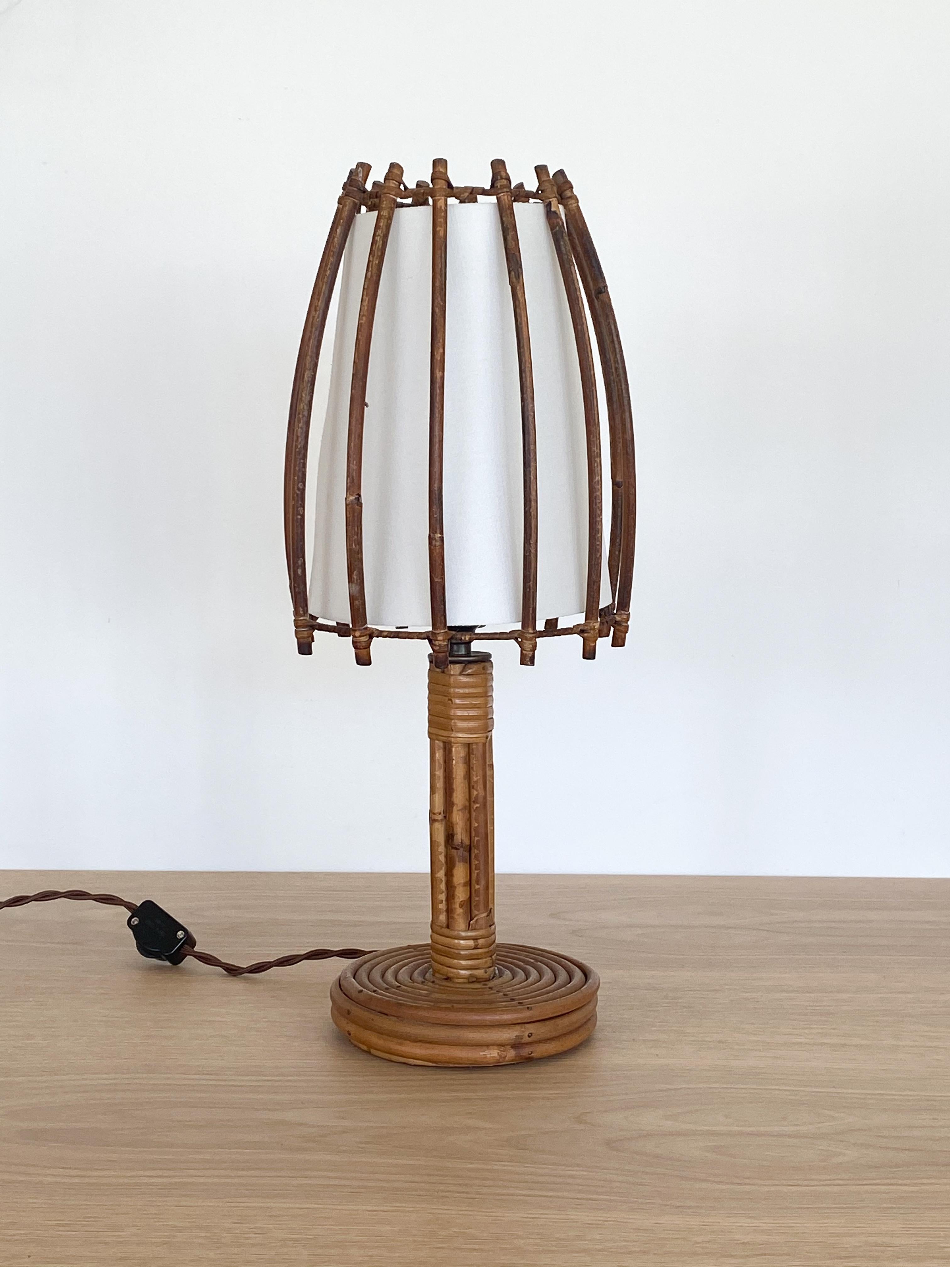 Vintage French rattan table lamp with long orb shaped shade, circular rattan base and stem. New silk interior shade and newly re-wired. 



 