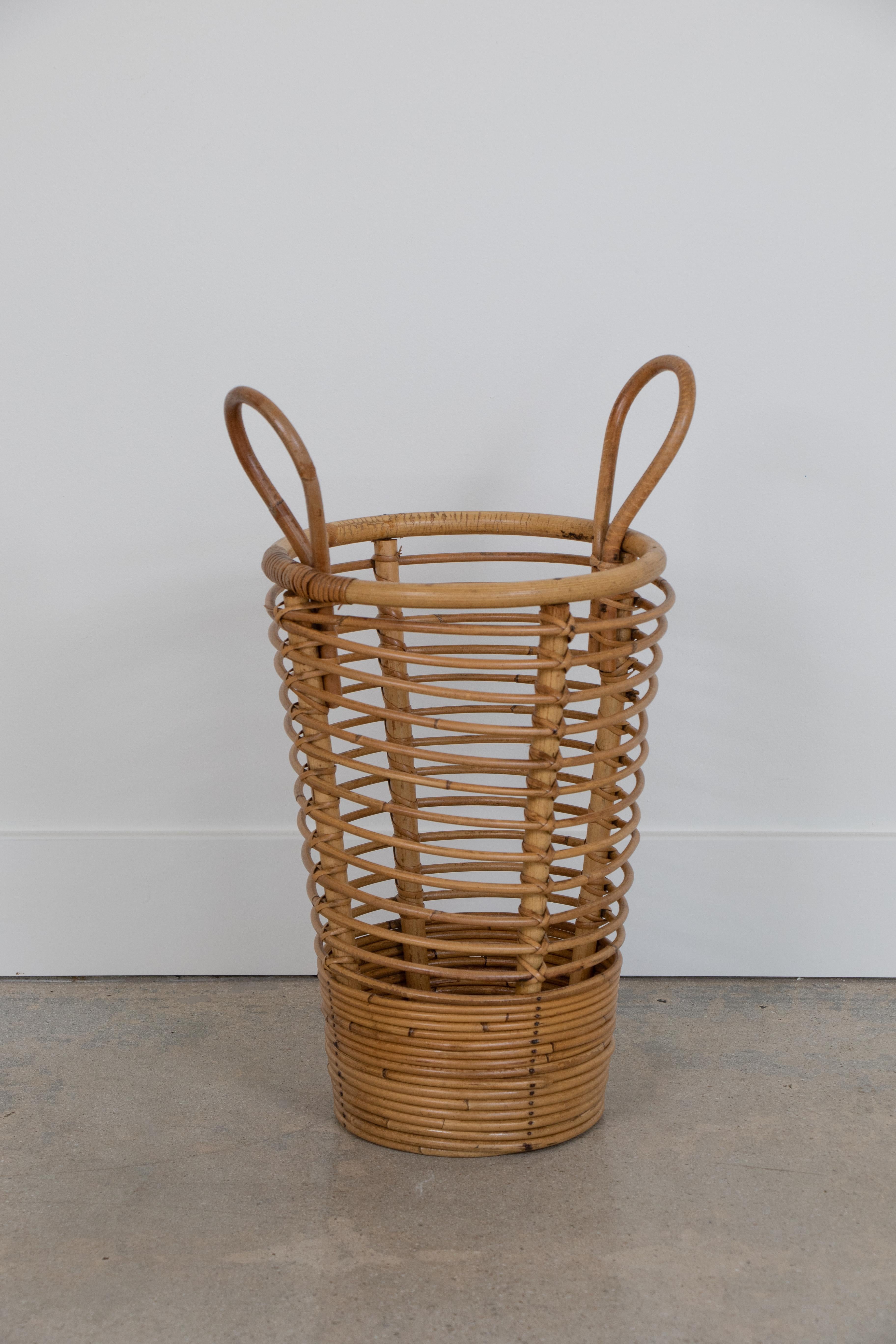 French rattan umbrella holder from the 1960s. Circular rattan base with two handles at top. Great natural coloring and patina.