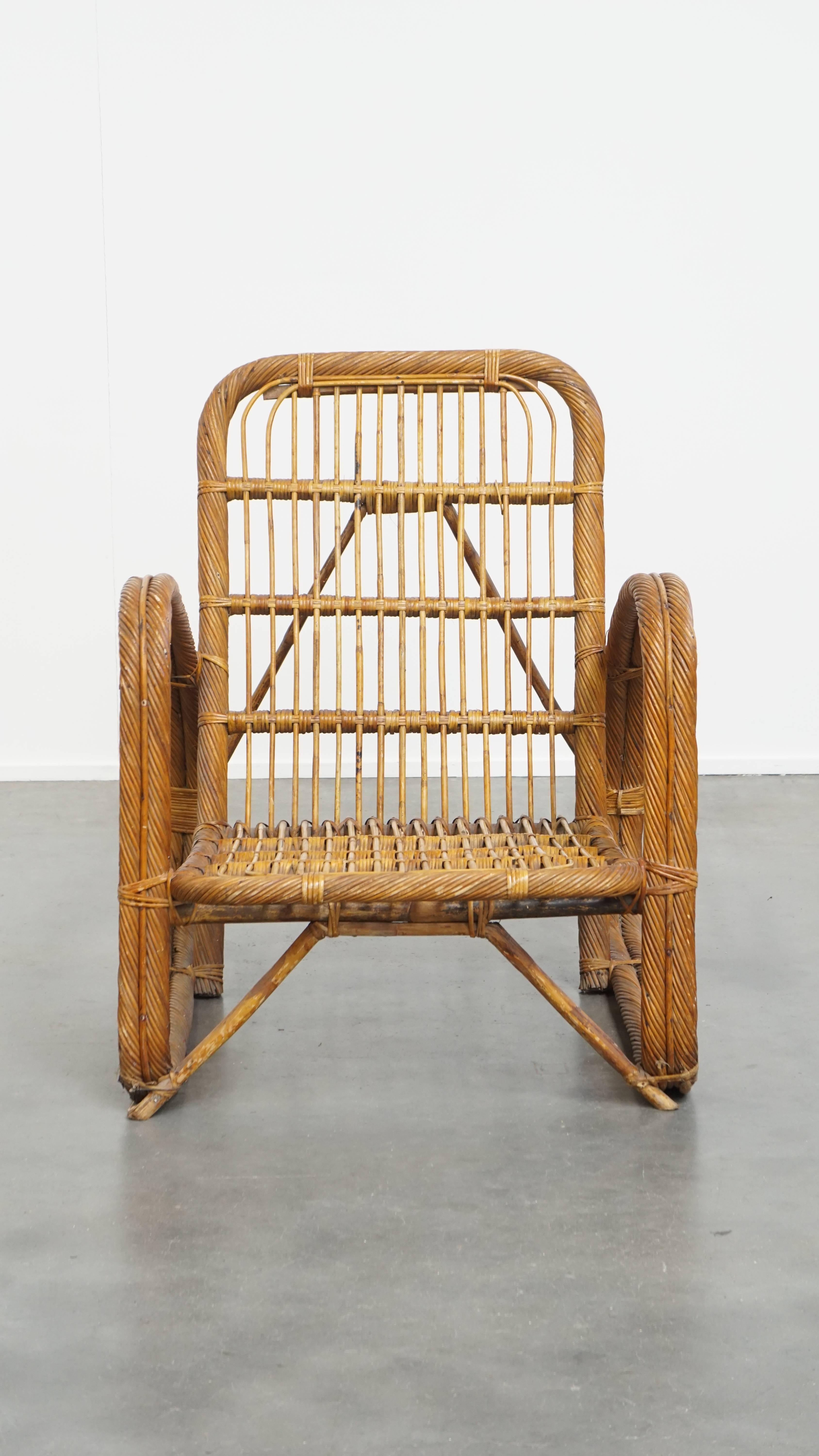 Offered here is this luxurious French rattan vintage design armchair from the 1950s.

This stunning and elegant vintage rattan armchair is a true eye-catcher, if you ask us. Not only is it easy to place outdoors or under a covered patio, but it also