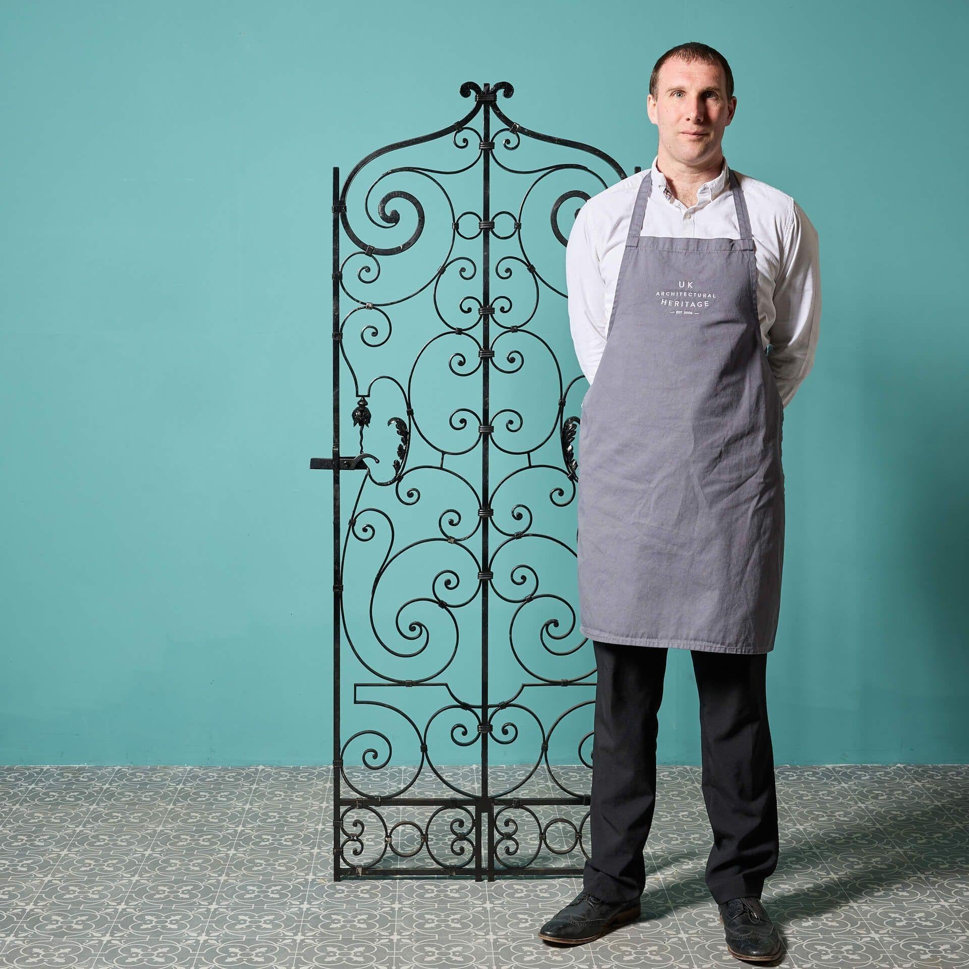 A stunning reclaimed early 20th century wrought iron side gate detailed with ornate scrollwork, originating from France. One of two matching gates that we have for sale.
 
With its tall and narrow proportions, this French garden gate is ideal for