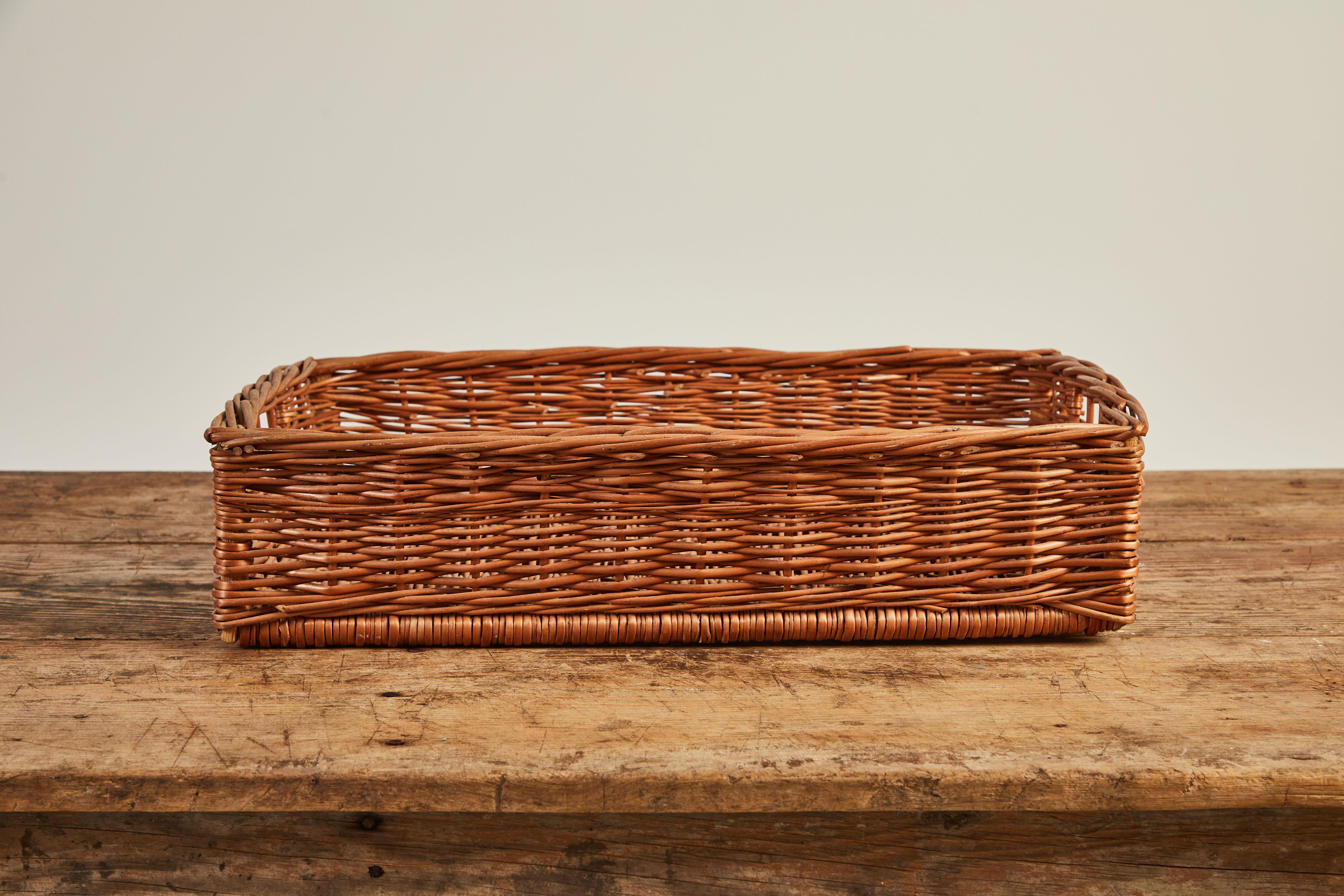 French rectangular woven basket tray with cutout handles on either side.