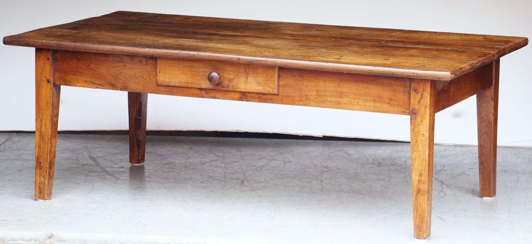 Ein großer französischer rechteckiger Couchtisch oder ein niedriger Tisch aus fein patiniertem Obstholz, mit einer hübschen Plankenplatte auf einem Rahmen aus vier verjüngten Beinen und einer gegenüberliegenden Schublade mit Knaufzug.

Das Ganze mit