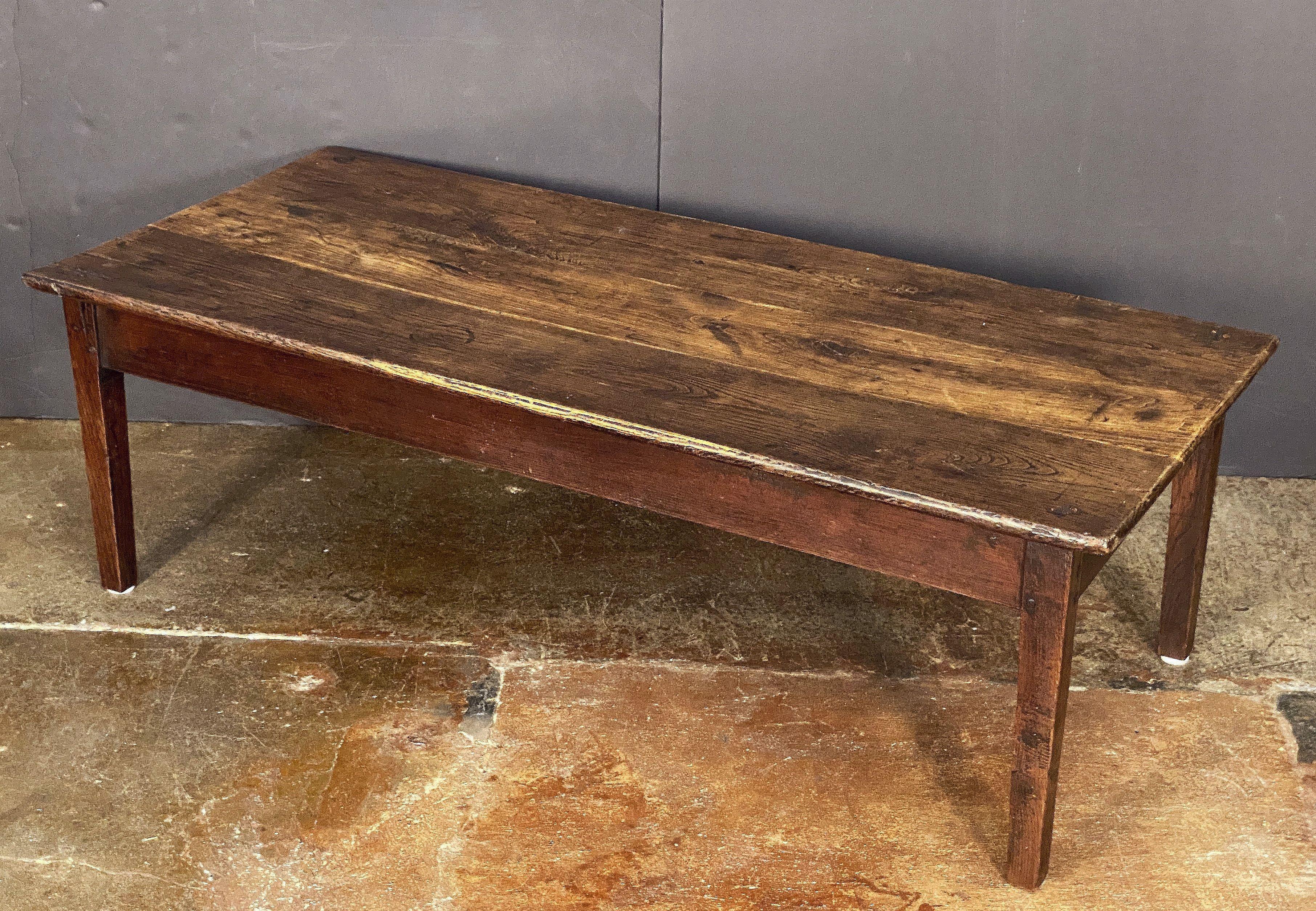 A large French rectangular coffee or low table of finely patinated oak, featuring a handsome plank top set upon a frame of four pegged and tapered legs.

The whole with a fine patina - perfect for use as a cocktail table.