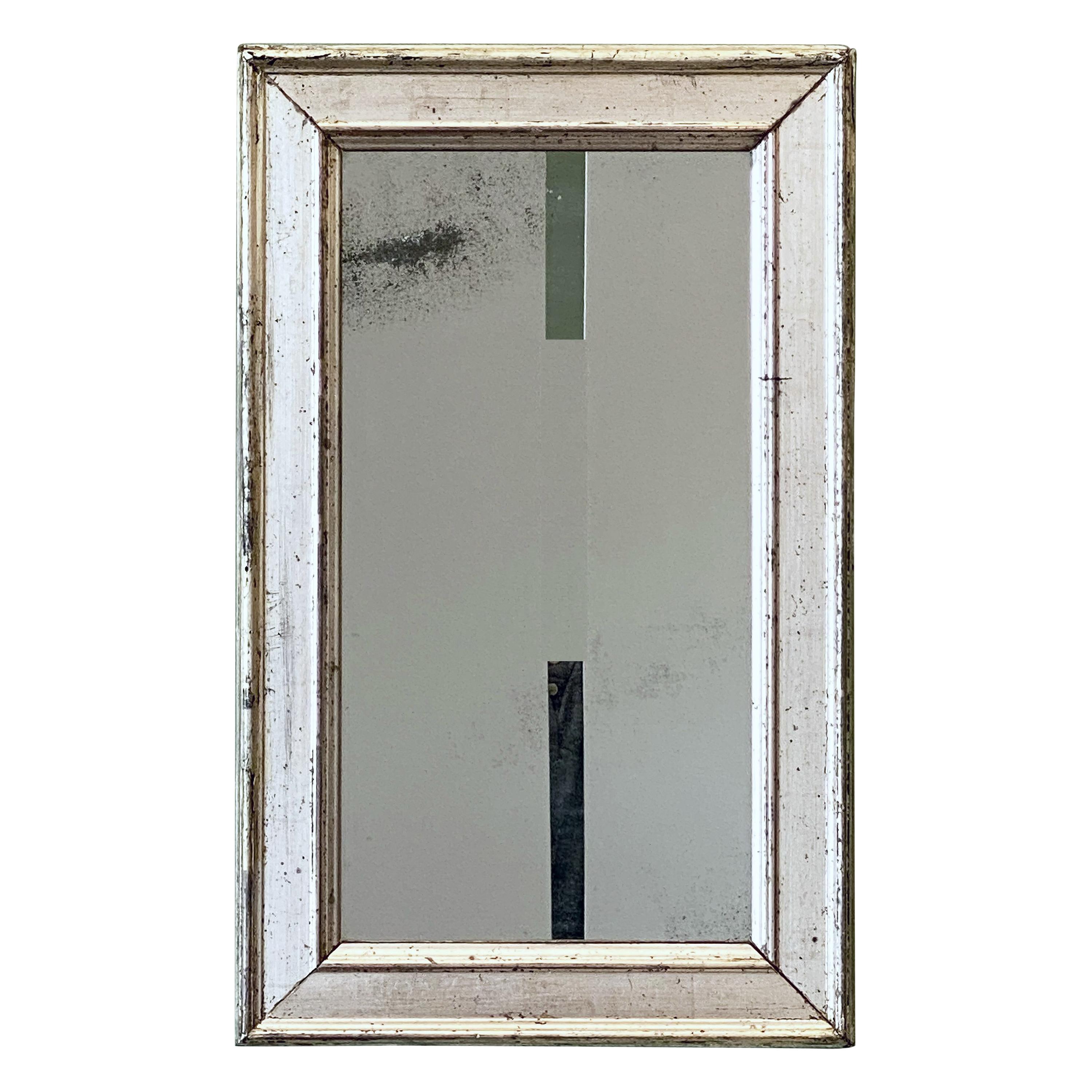 A fine French wall mirror from the 19th c., featuring a silver gilt rectangular frame around an original mirrored glass.

Dimensions are H 19 1/2 inches x W 12 1/4 inches.
