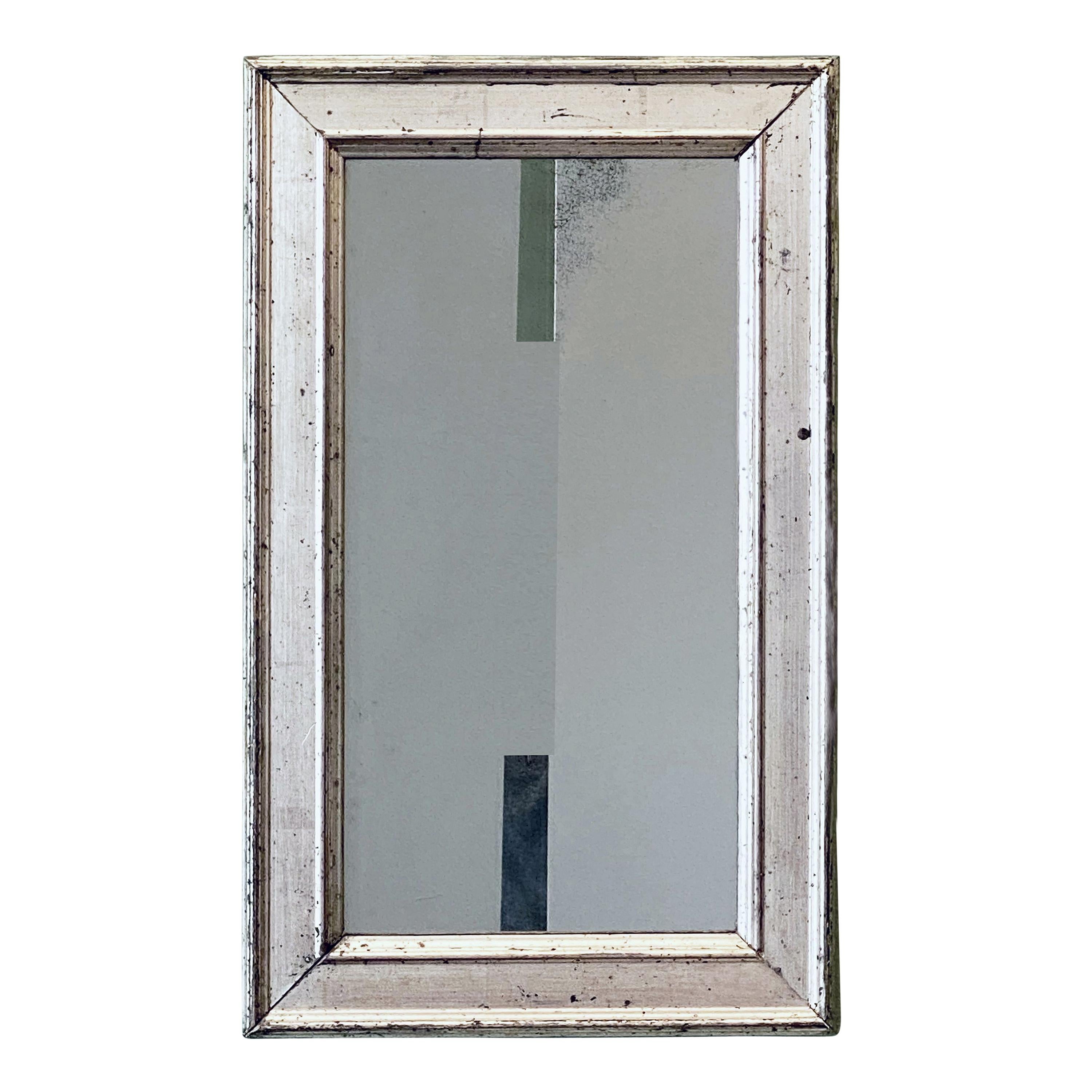 A fine French wall mirror from the 19th c., featuring a silver gilt rectangular frame around an original mirrored glass.

Dimensions are H 19 1/2 inches x W 12 1/4 inches.
   