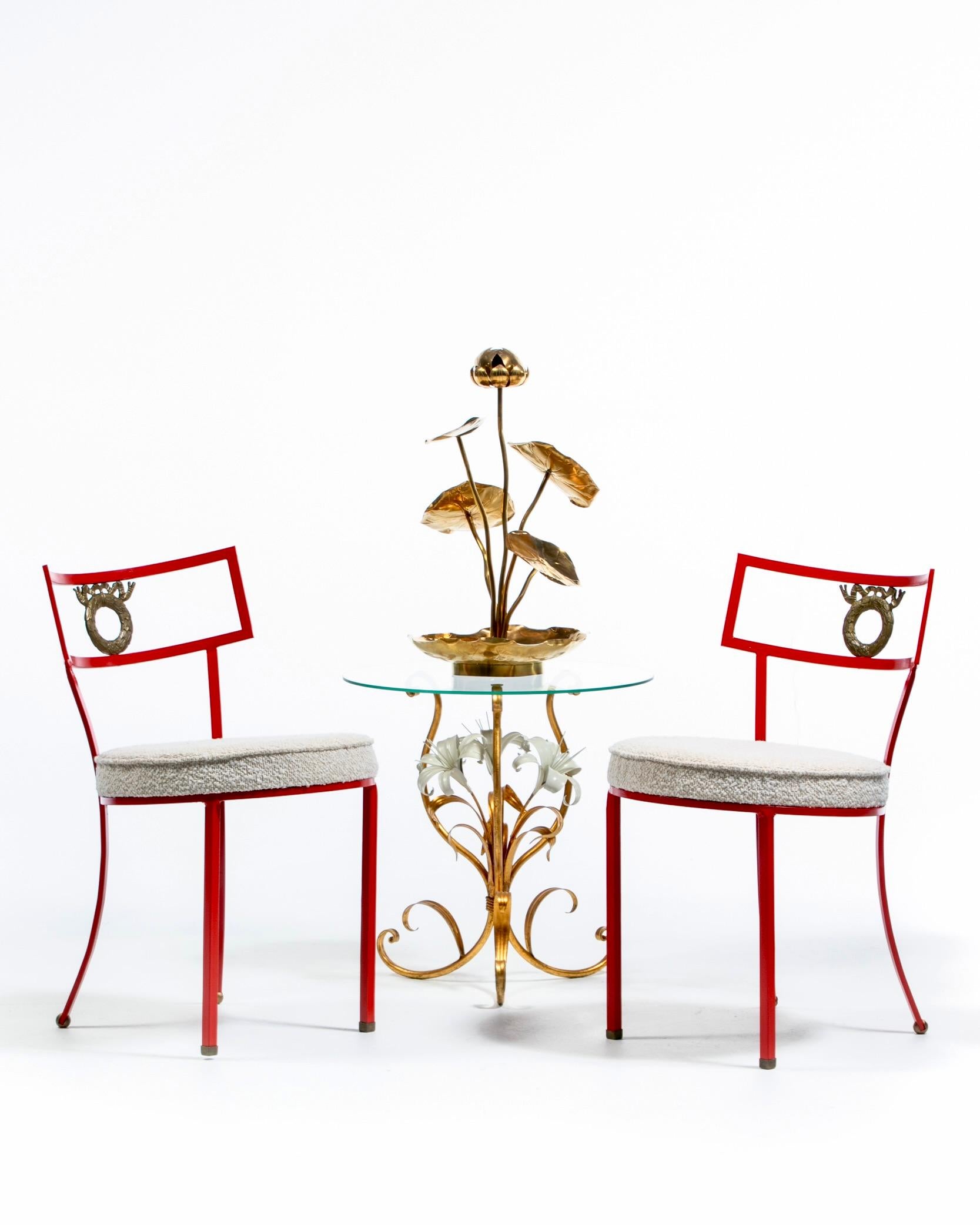 A most gregarious and timelessly elegant pair of newly fully restored French red iron side chairs with brass wreath and feet details. Every angle of these chic French chairs emanates a sense of high style and confidence. Fashionable finishes.