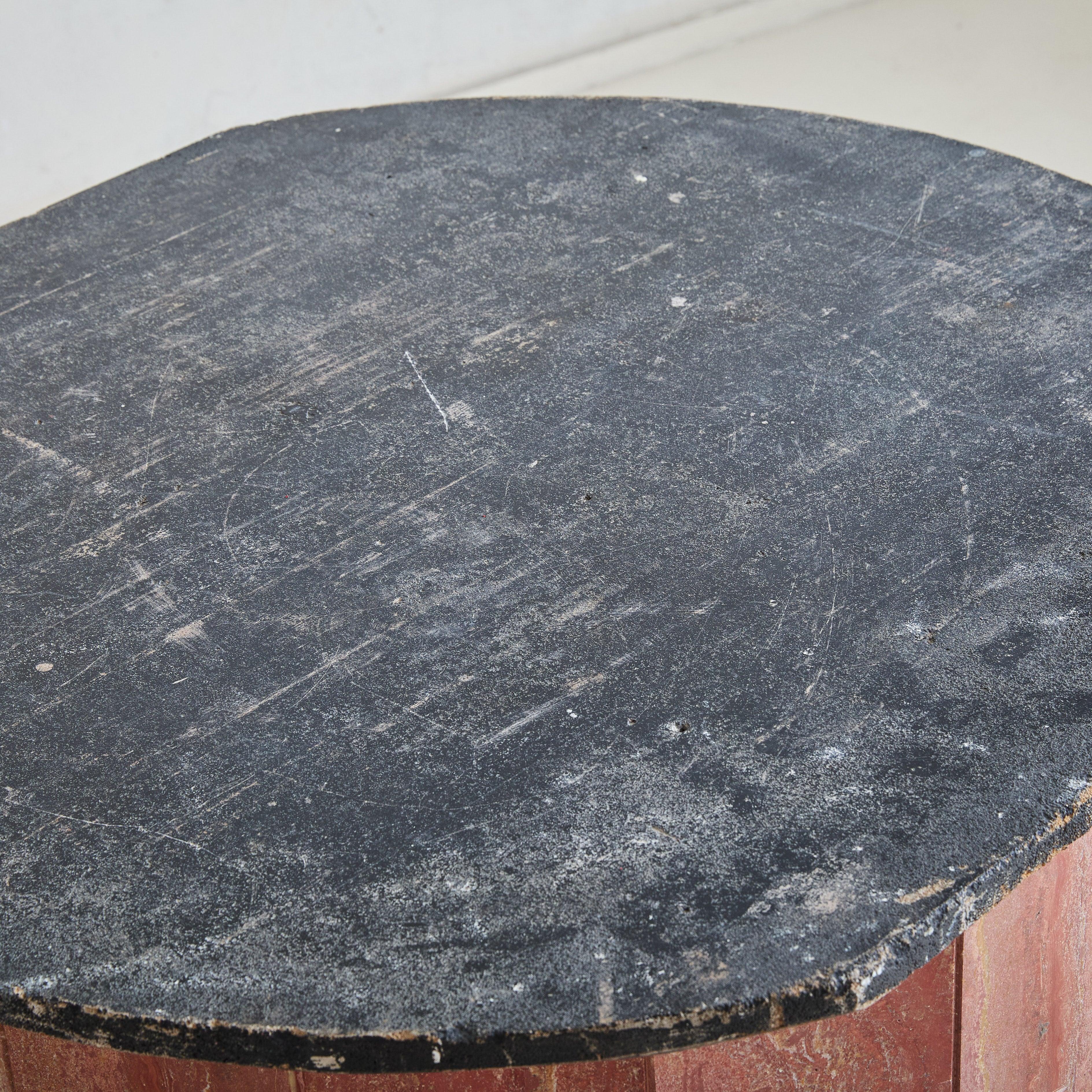 A 1980s French pedestal table, characterized by its architectural, faceted silhouette crafted from richly veined red marble. The cylindrical base introduces warmth and depth, perfectly complementing the contrasting black stone top.
Good vintage