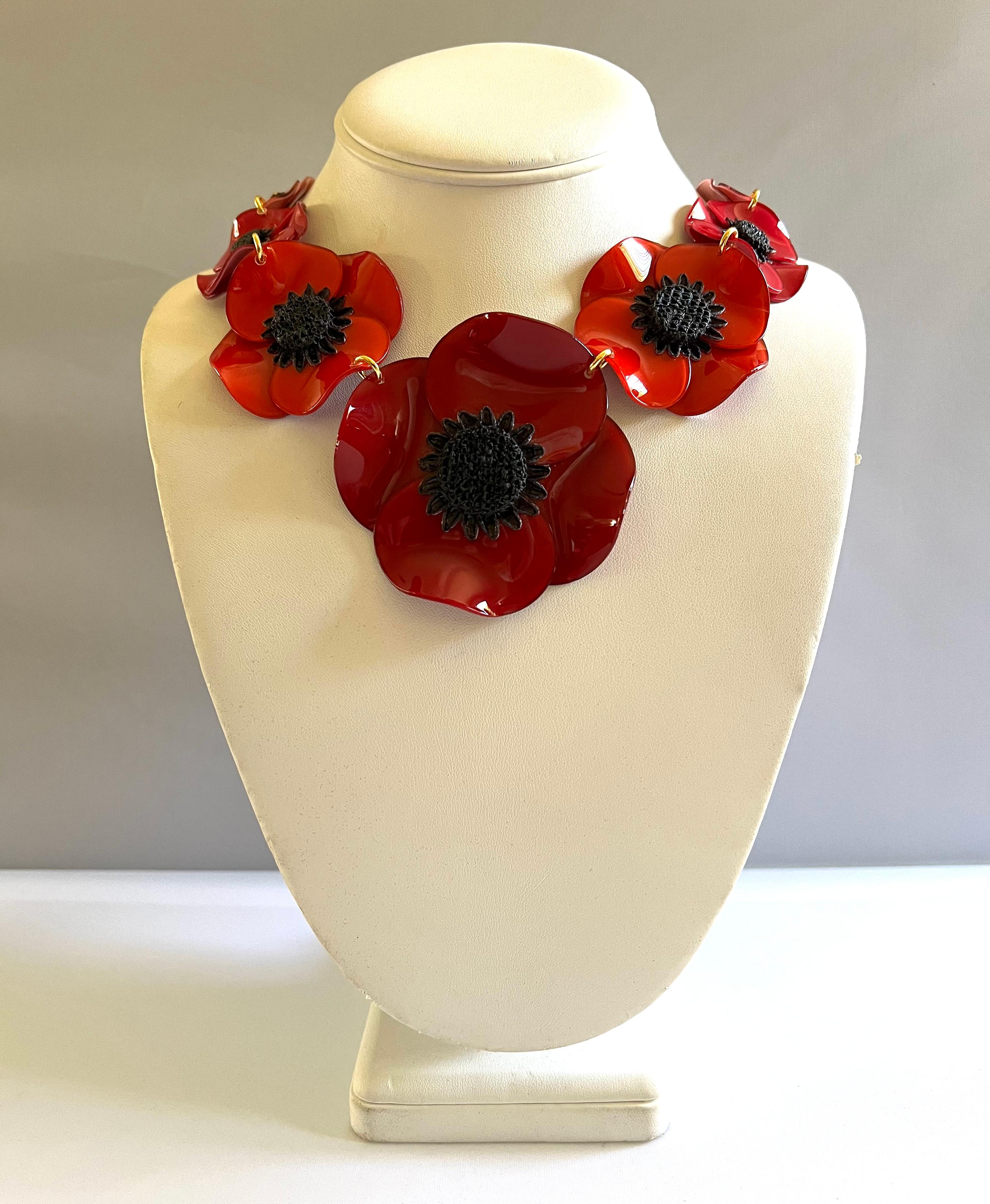 Light and easy to wear, the contemporary handmade adjustable artisanal necklace was made in Paris by Cilea. The statement necklace features seven three-dimensional enameline (enamel and resin composite) poppy flowers in red and pink. The poppies
