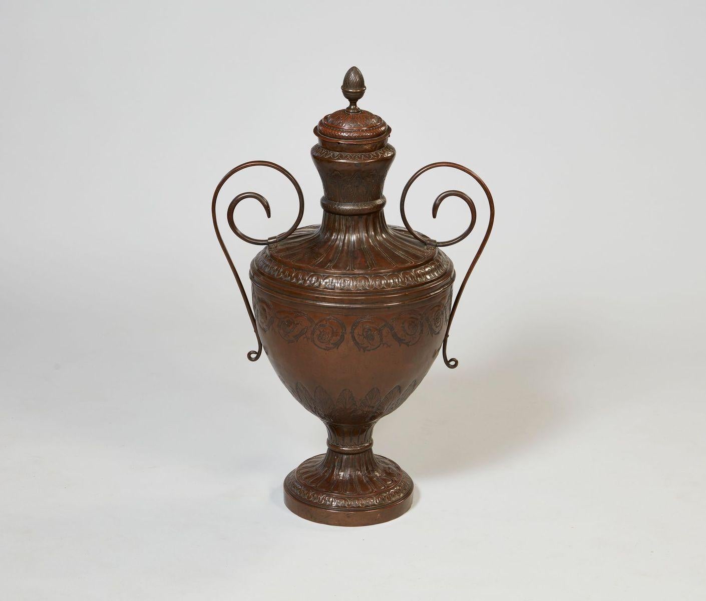 Rare and substantial French early 18th century copper wine urn, the acanthus leaf decorated lid with pineapple finial, the gadrooned body with scrolled handles, the whole profusely chased and etched surface depicting classical motifs and having