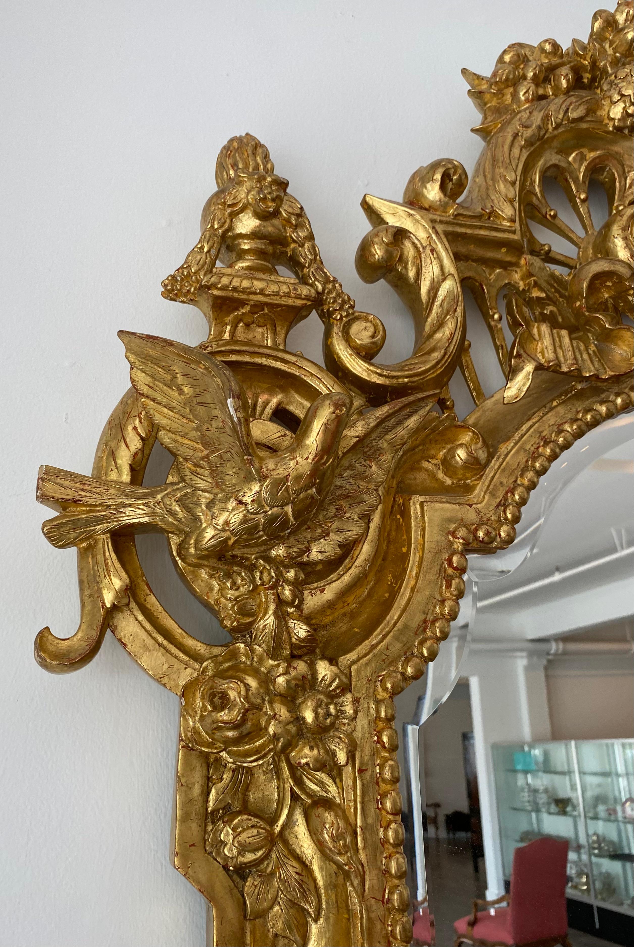 Sculpté à la main Grand miroir biseauté en bois doré de la Régence, sculpté à la main de vases et de crêtes d'oiseaux en vente
