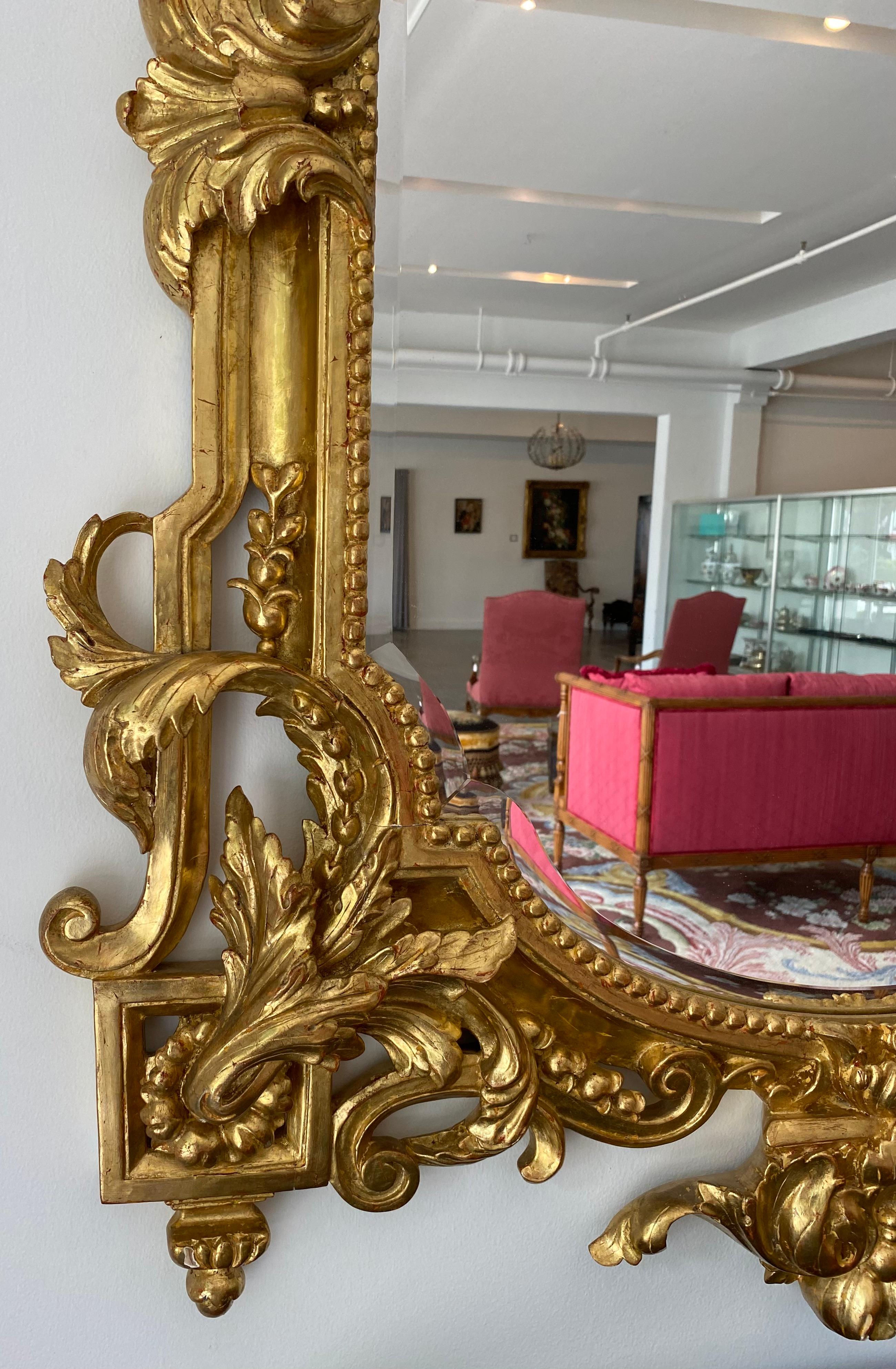 Miroir Grand miroir biseauté en bois doré de la Régence, sculpté à la main de vases et de crêtes d'oiseaux en vente