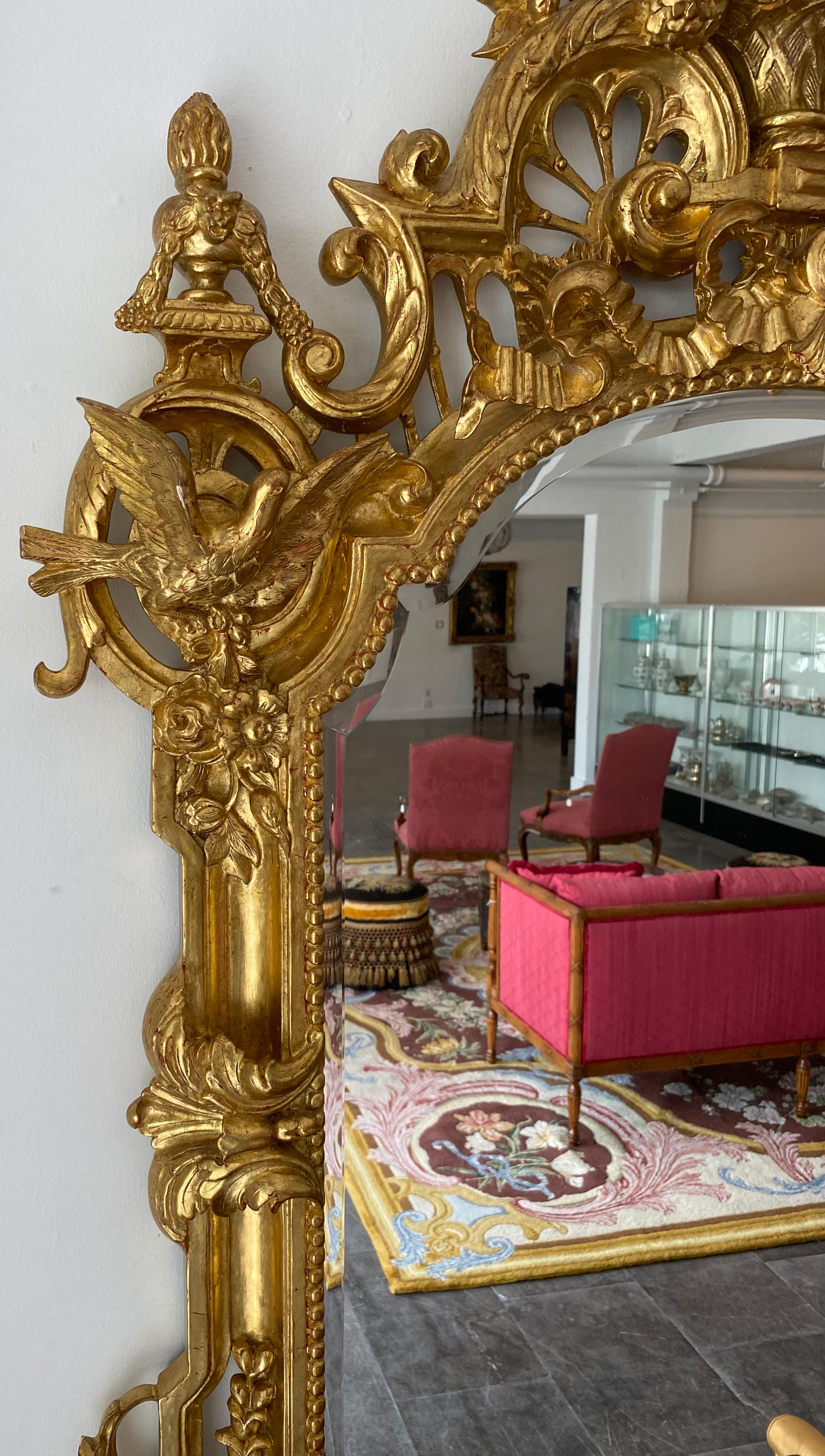 Grand miroir biseauté en bois doré de la Régence, sculpté à la main de vases et de crêtes d'oiseaux en vente 1