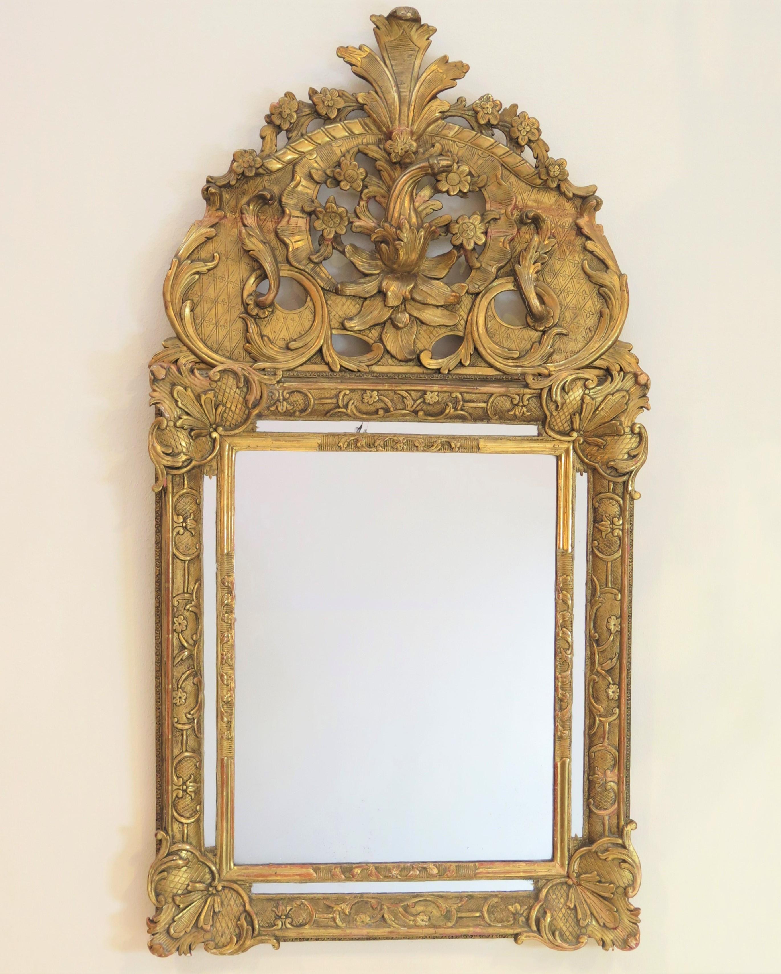 a Régence mirror, elaborately carved and gilded with squash / gourd pediment, France, 18th century