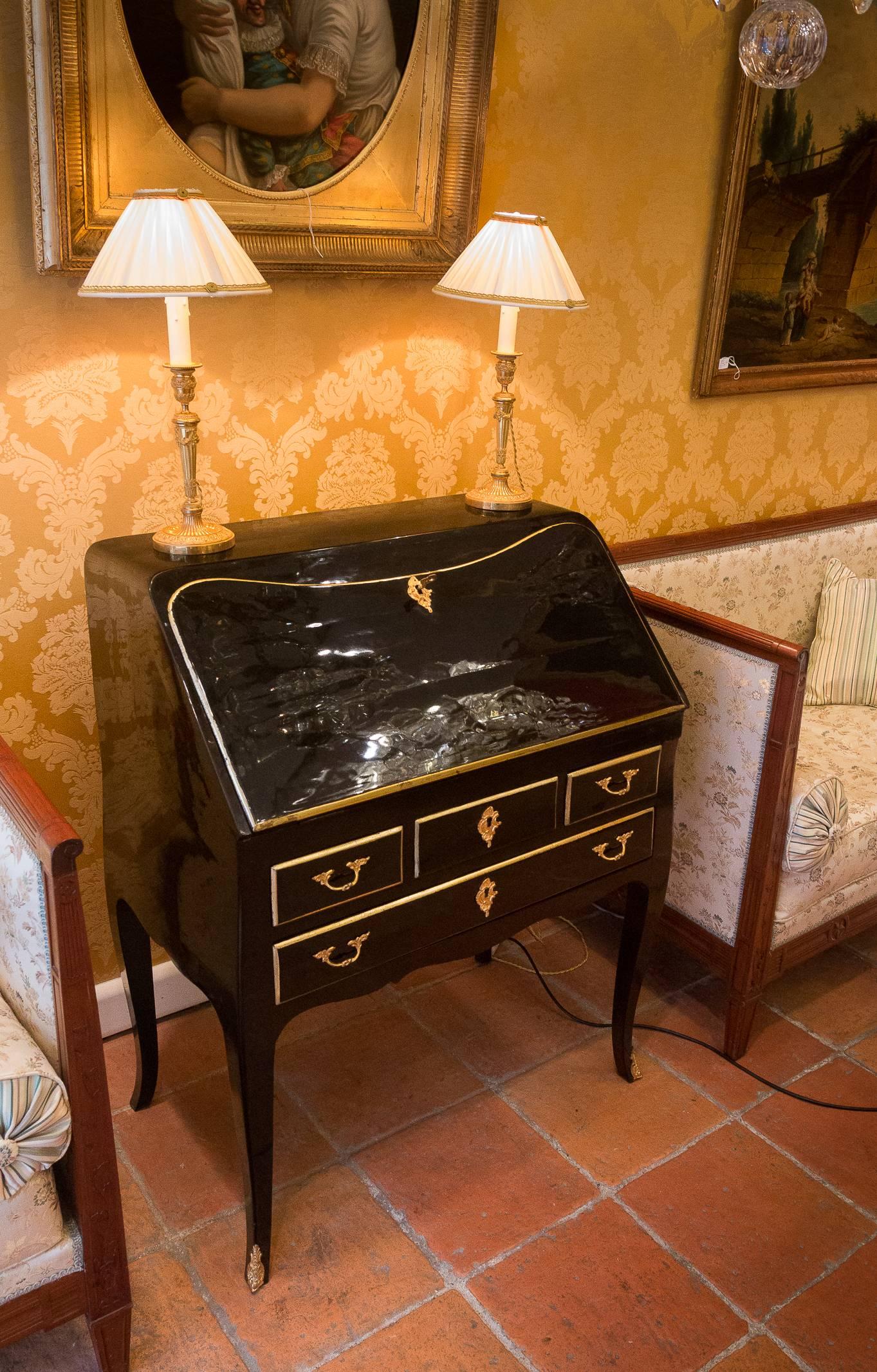 We are pleased to present you, a gorgeous French Regence period black lacquered slant-top desk. 

Our desk has a lovely interior which includes a stepped interior with six drawers, a secret compartment, and a beautiful tooled leather writing