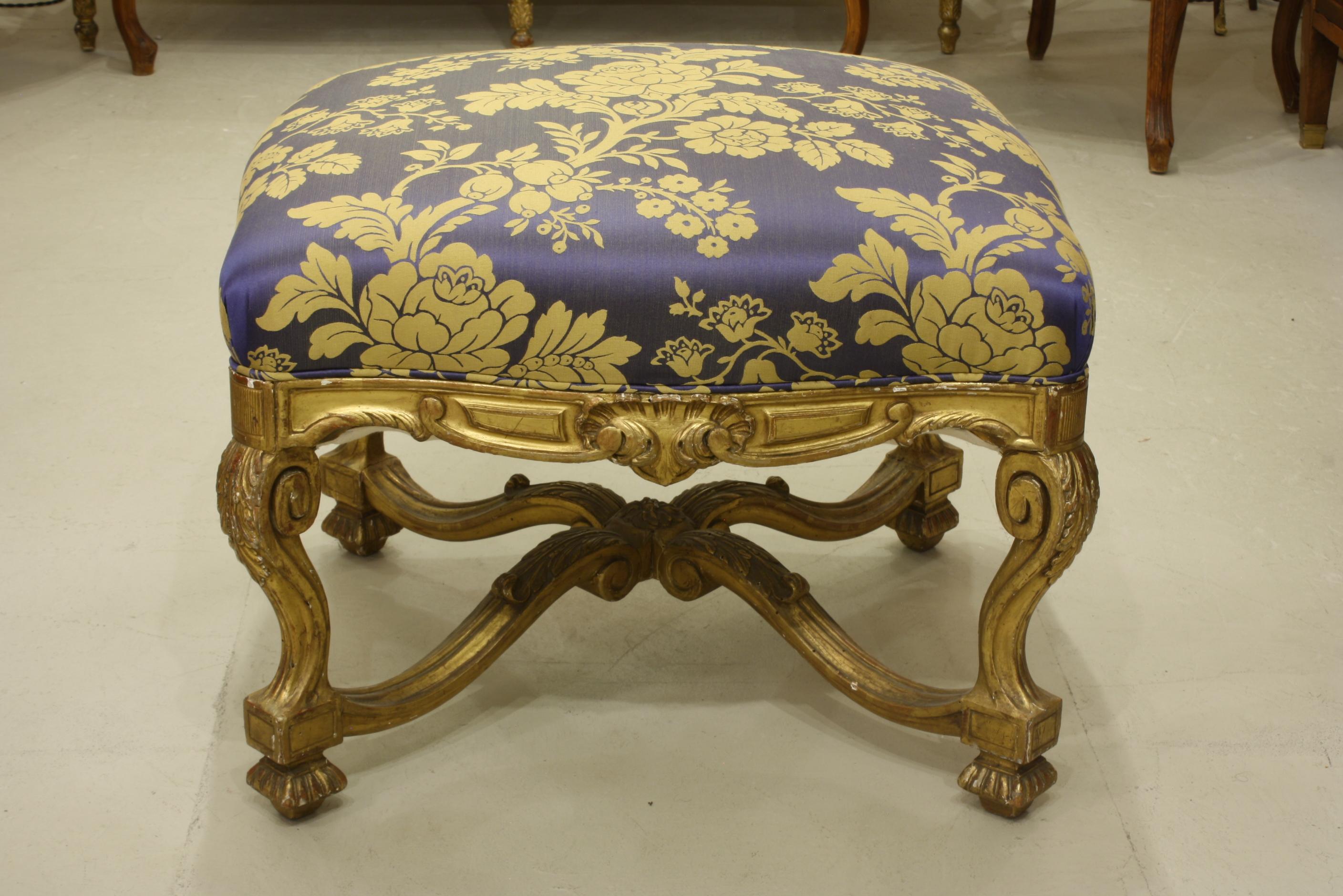 French Regence style carved giltwood stool, tabouret or ottoman with stretcher. The tabouret has been reupholstered in silk damask fabric.