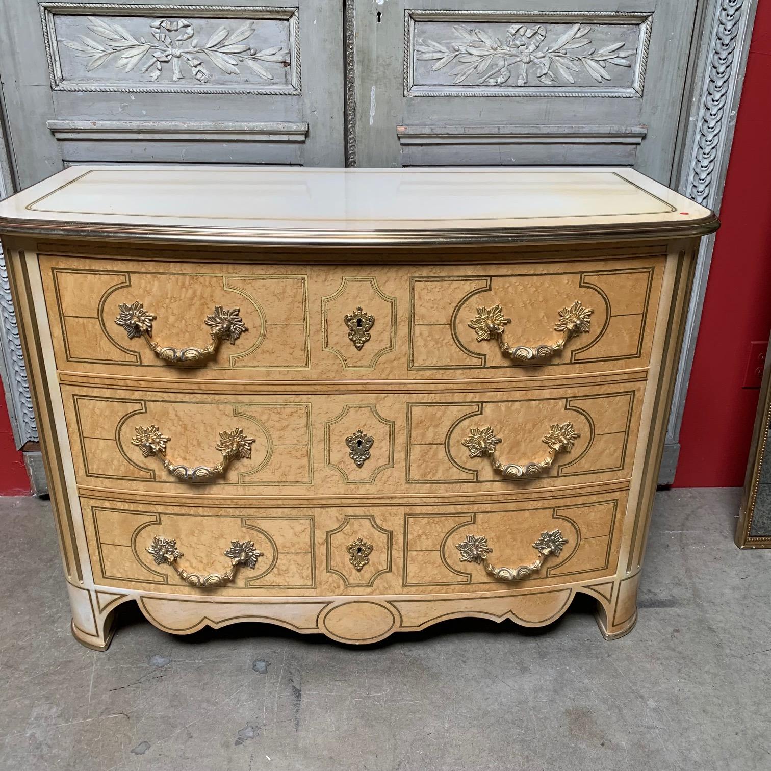 A French Regence style commode in mable and lacquer with inlayed brass and bronze dore hardware. This chest of drawers is by Maison Romeo and dates from the early 1980s. It is beautifully made and in nice condition.
